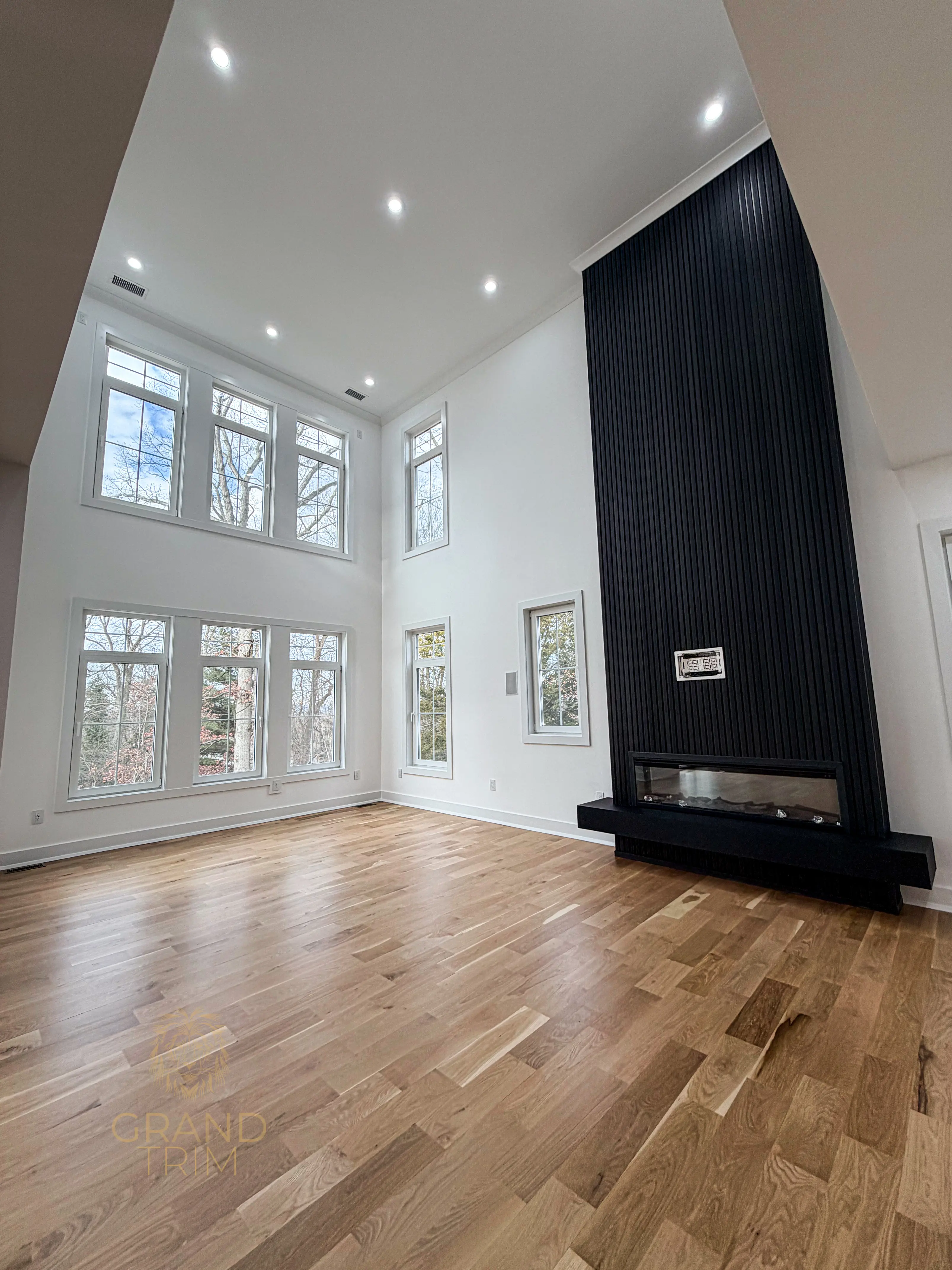 Black fluted fireplace surround with linear firebox in a modern New Jersey living room with vaulted ceiling