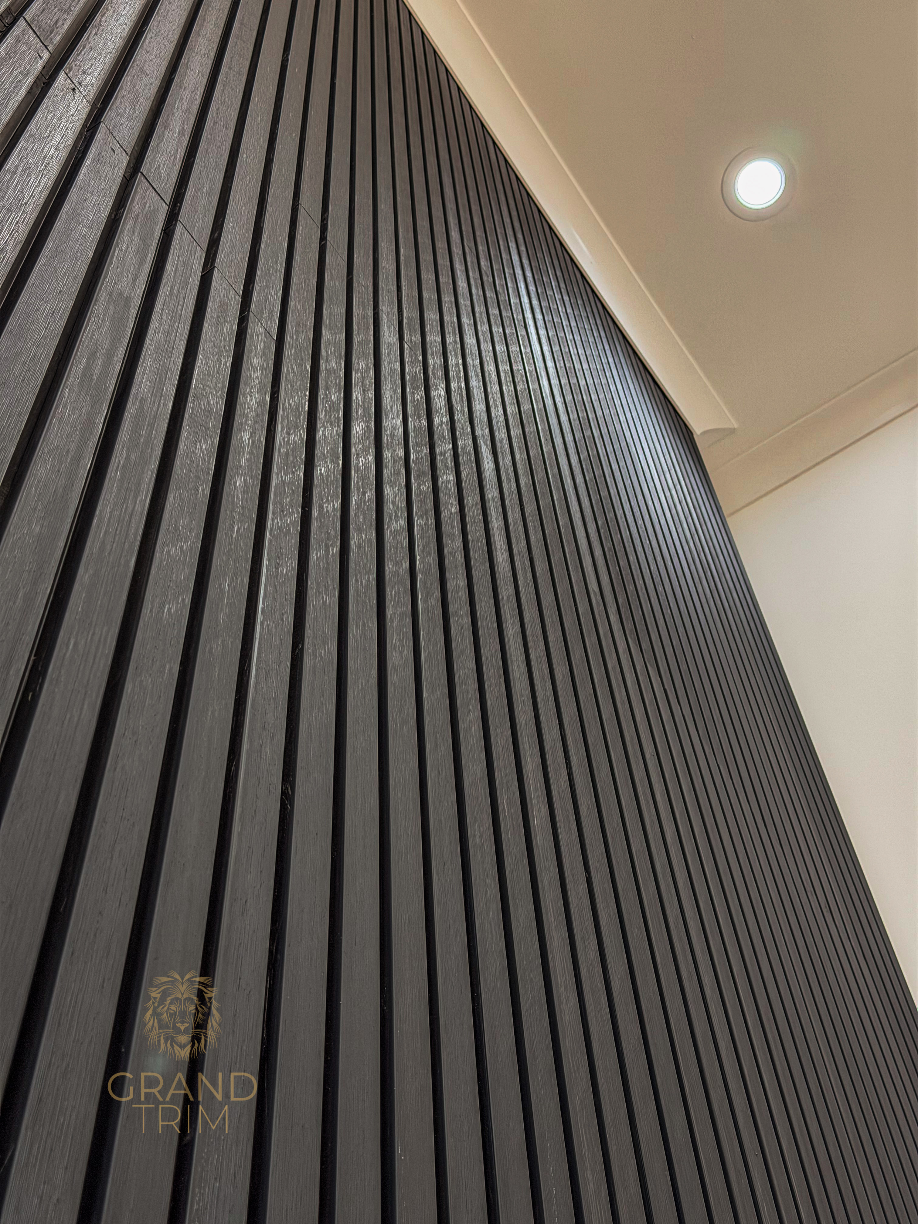 Dark wood slat wall paneling with white crown molding in a modern New Jersey interior