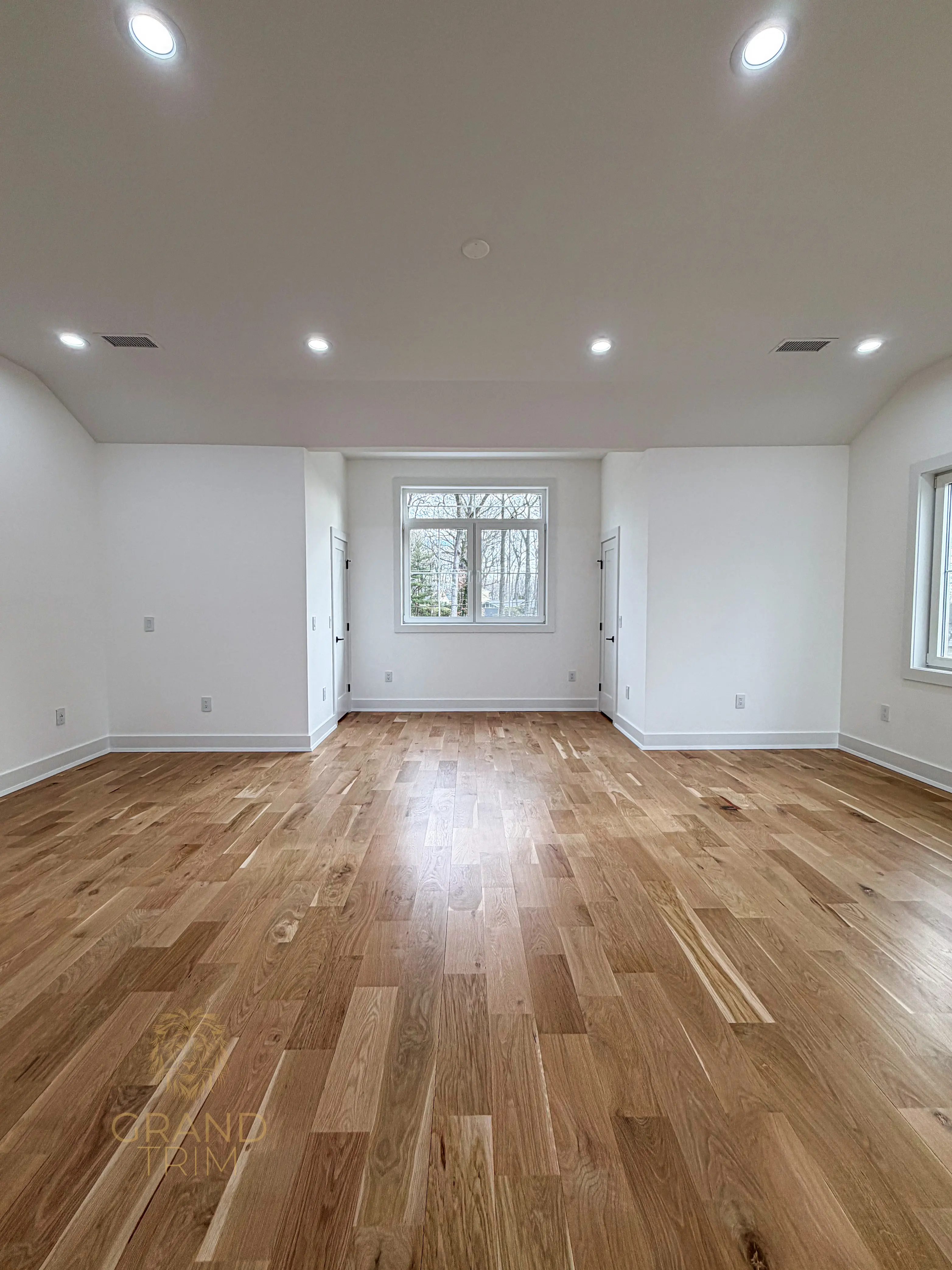 Newly installed white trim around windows, doors, and baseboards in a spacious New Jersey room