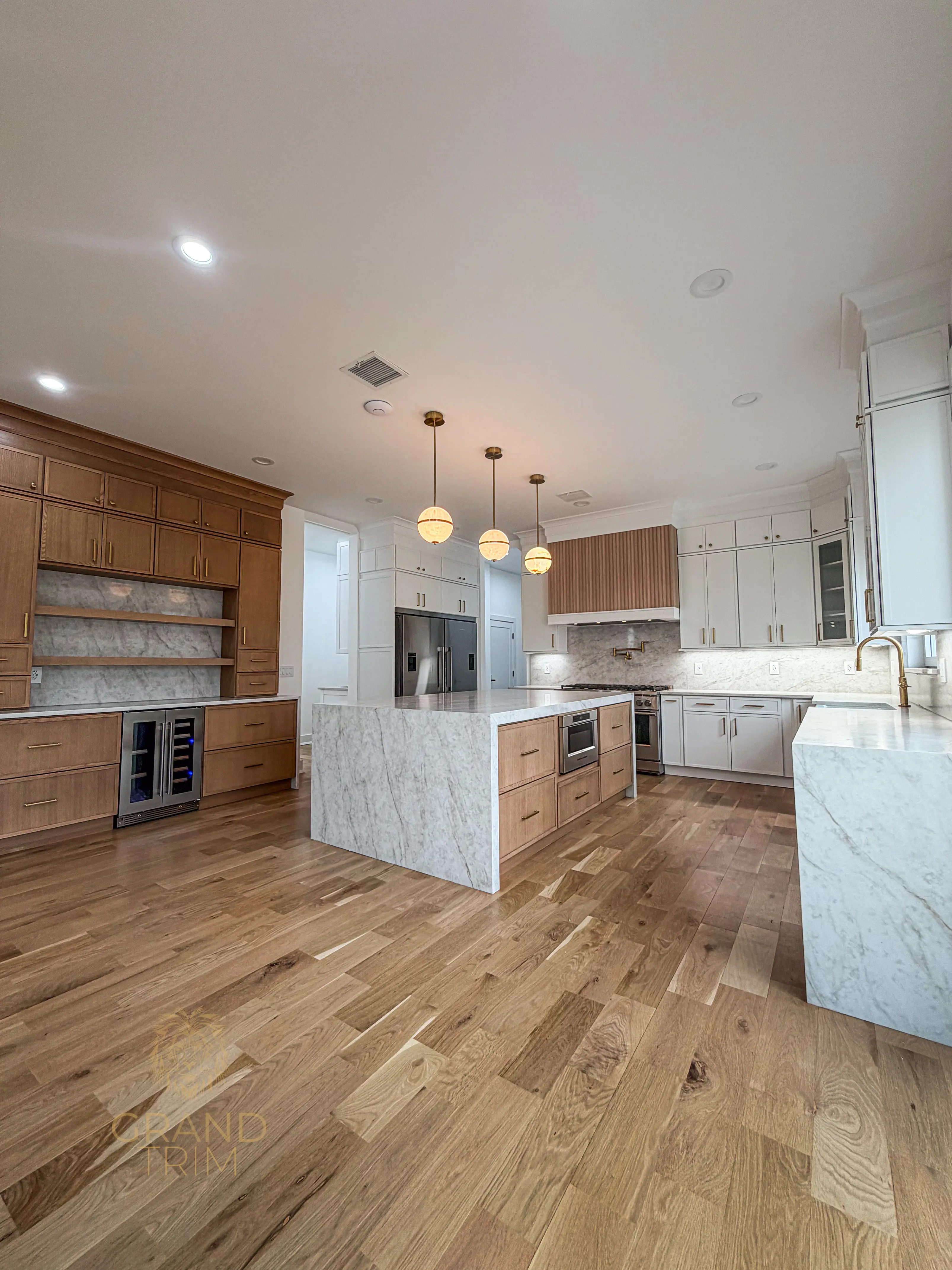 Custom white and natural wood kitchen cabinetry with marble countertops and decorative crown molding in a New Jersey home