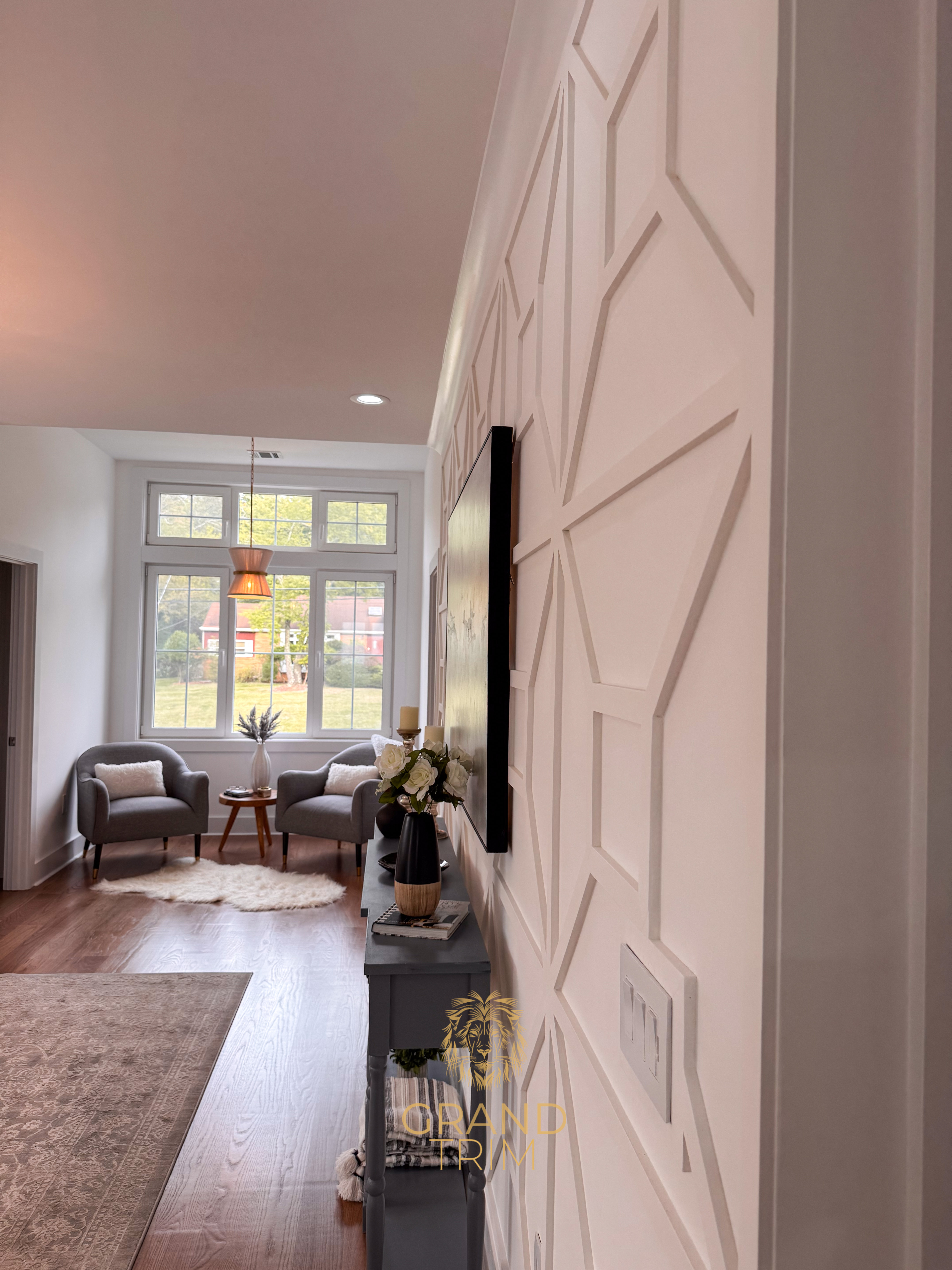 White geometric wall paneling with decorative trim and crown molding in a New Jersey living room