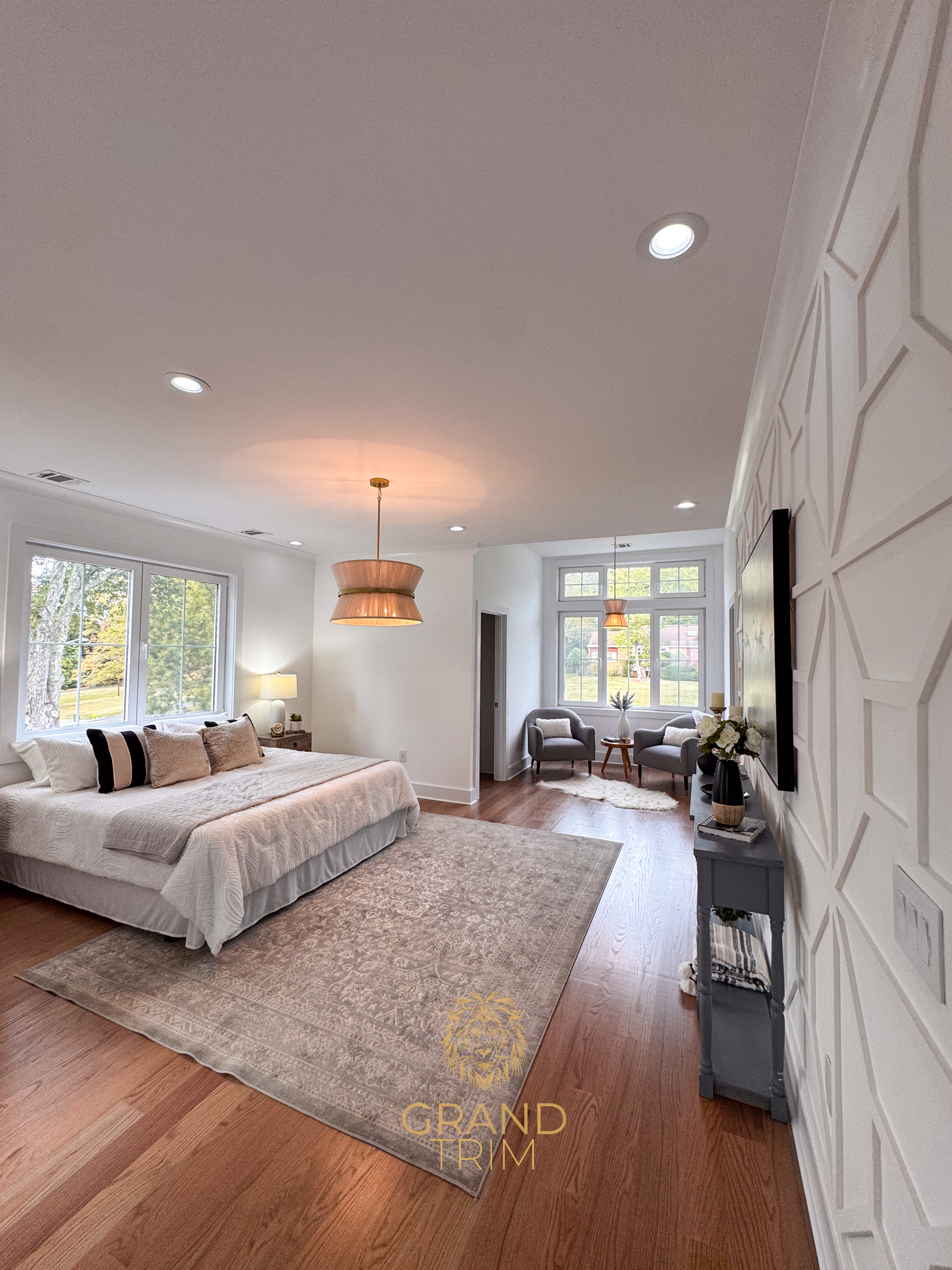 White geometric wall paneling and crown molding in a spacious primary bedroom in New Jersey