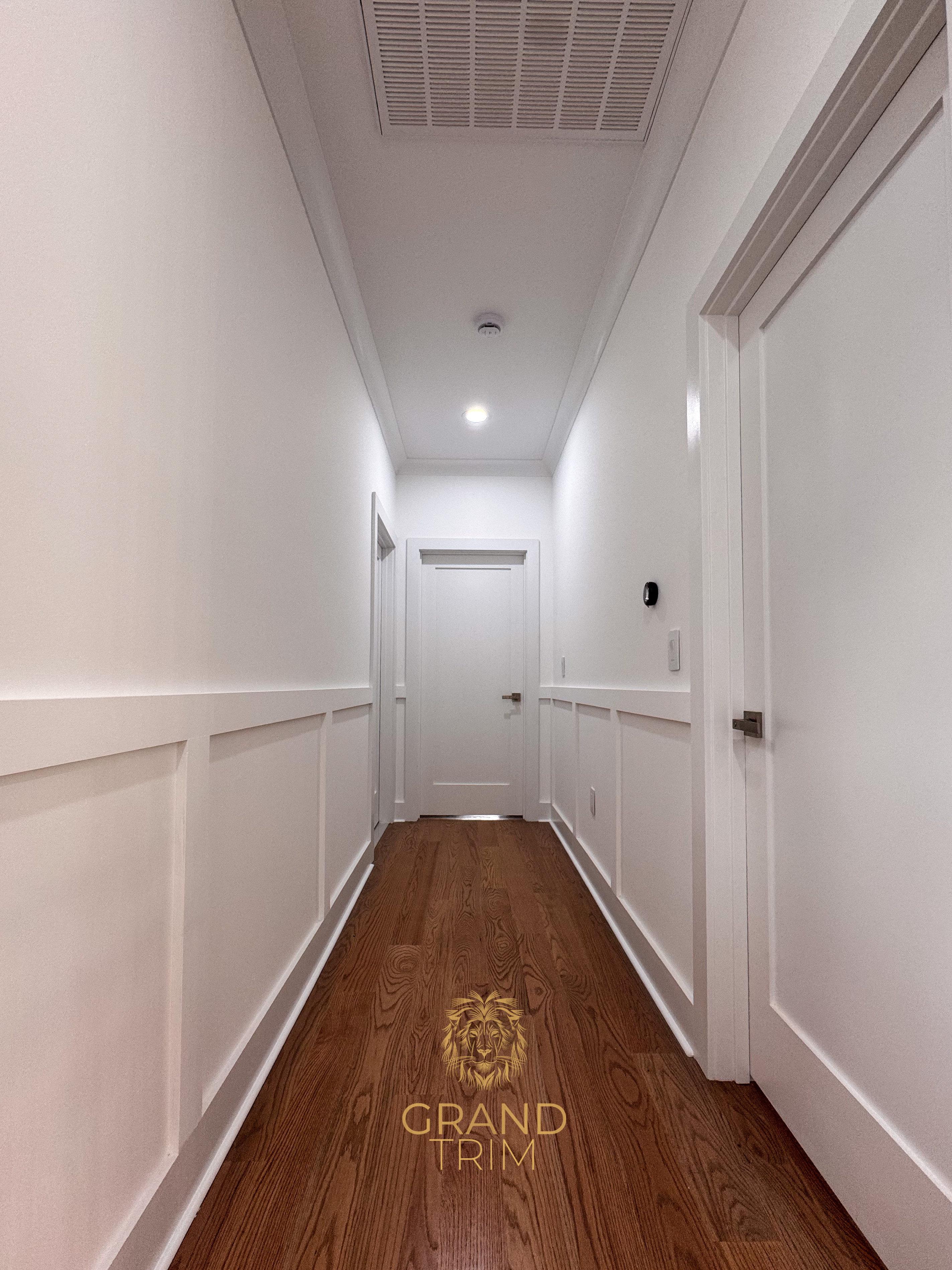 Modern New Jersey hallway featuring white board-and-batten wall paneling and a recessed tray ceiling