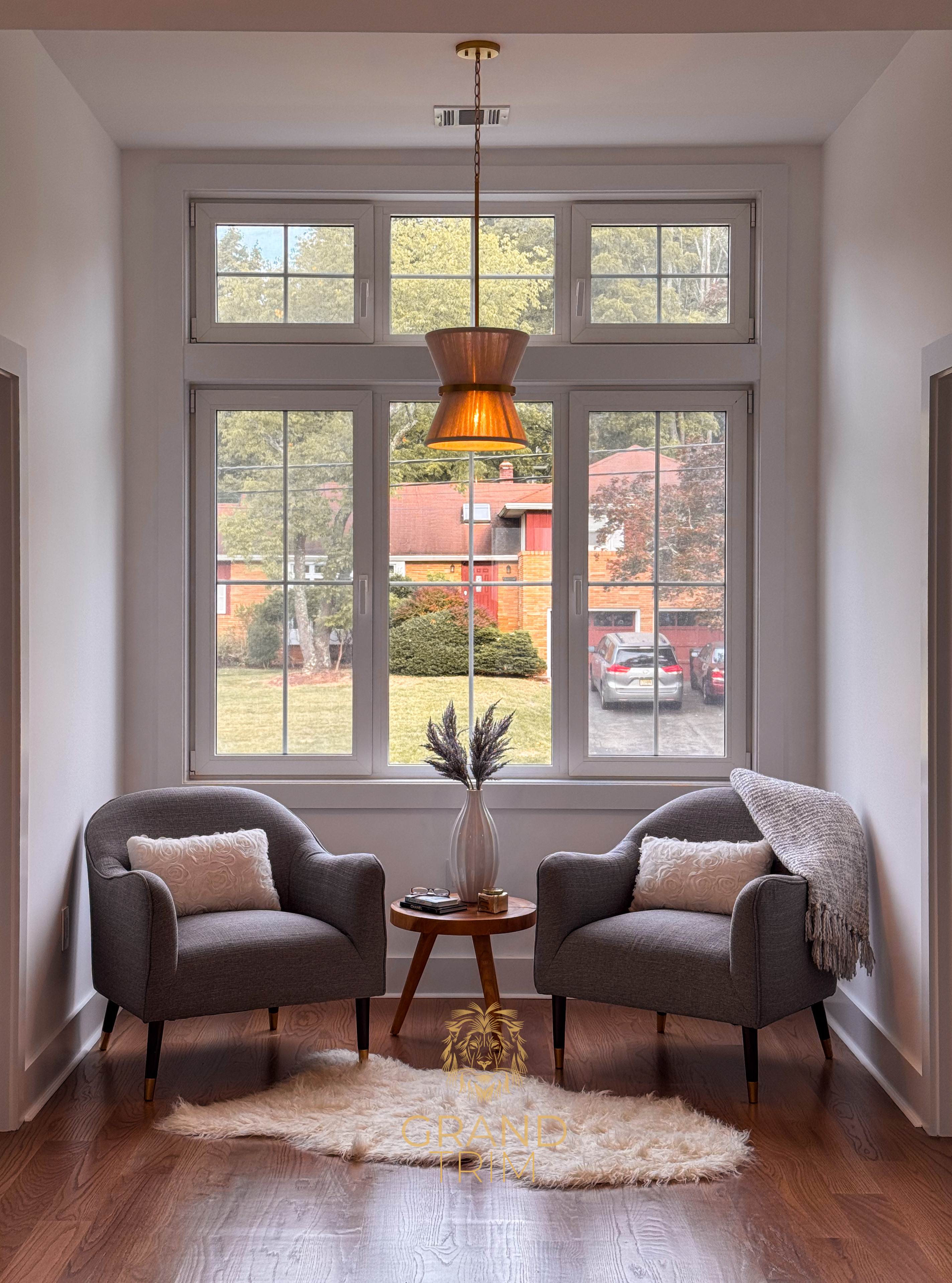 White window trim installed around a large multi-pane window in a cozy NJ reading nook