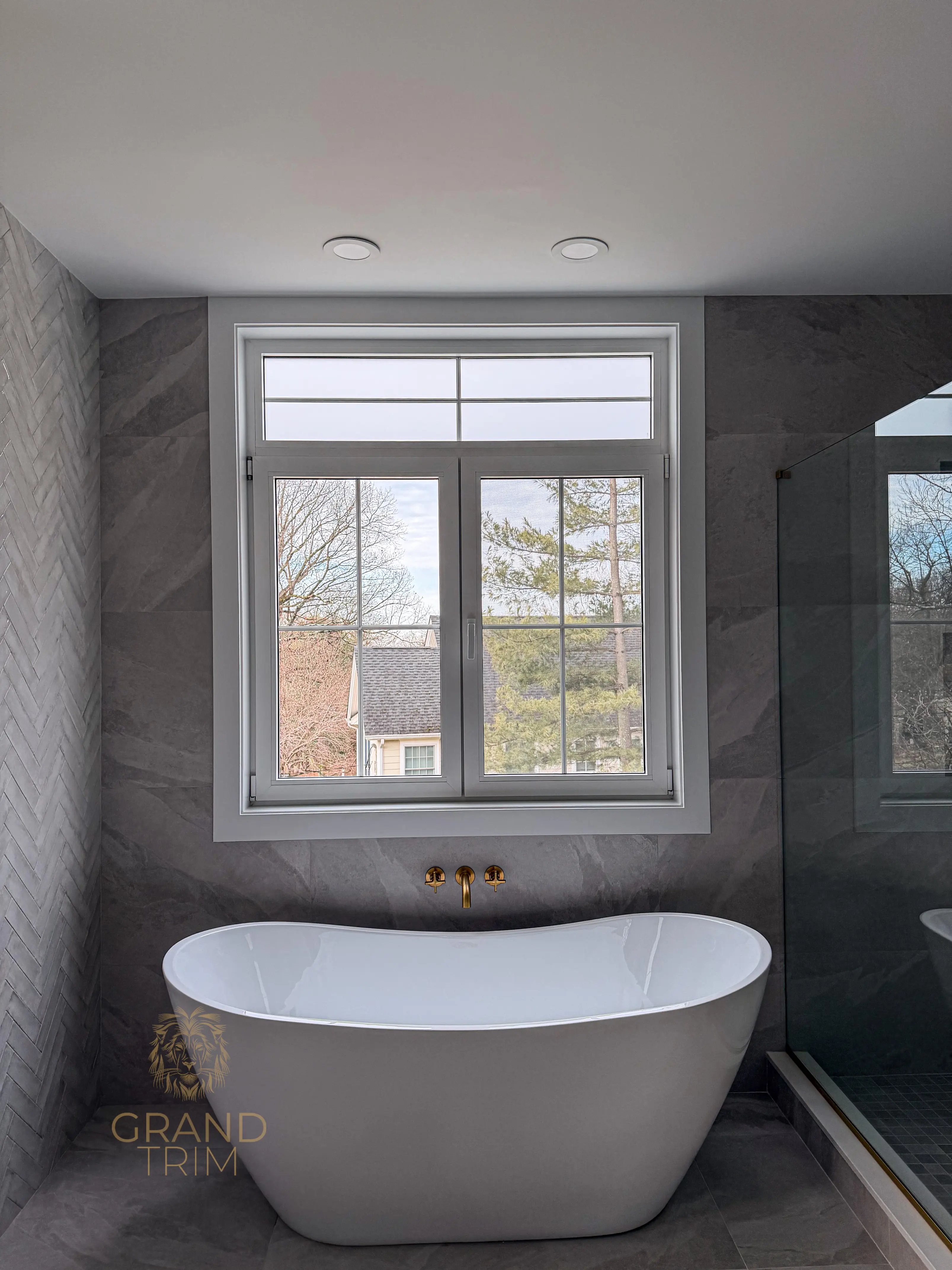 White window trim in a modern New Jersey bathroom with a freestanding tub and grey tiles
