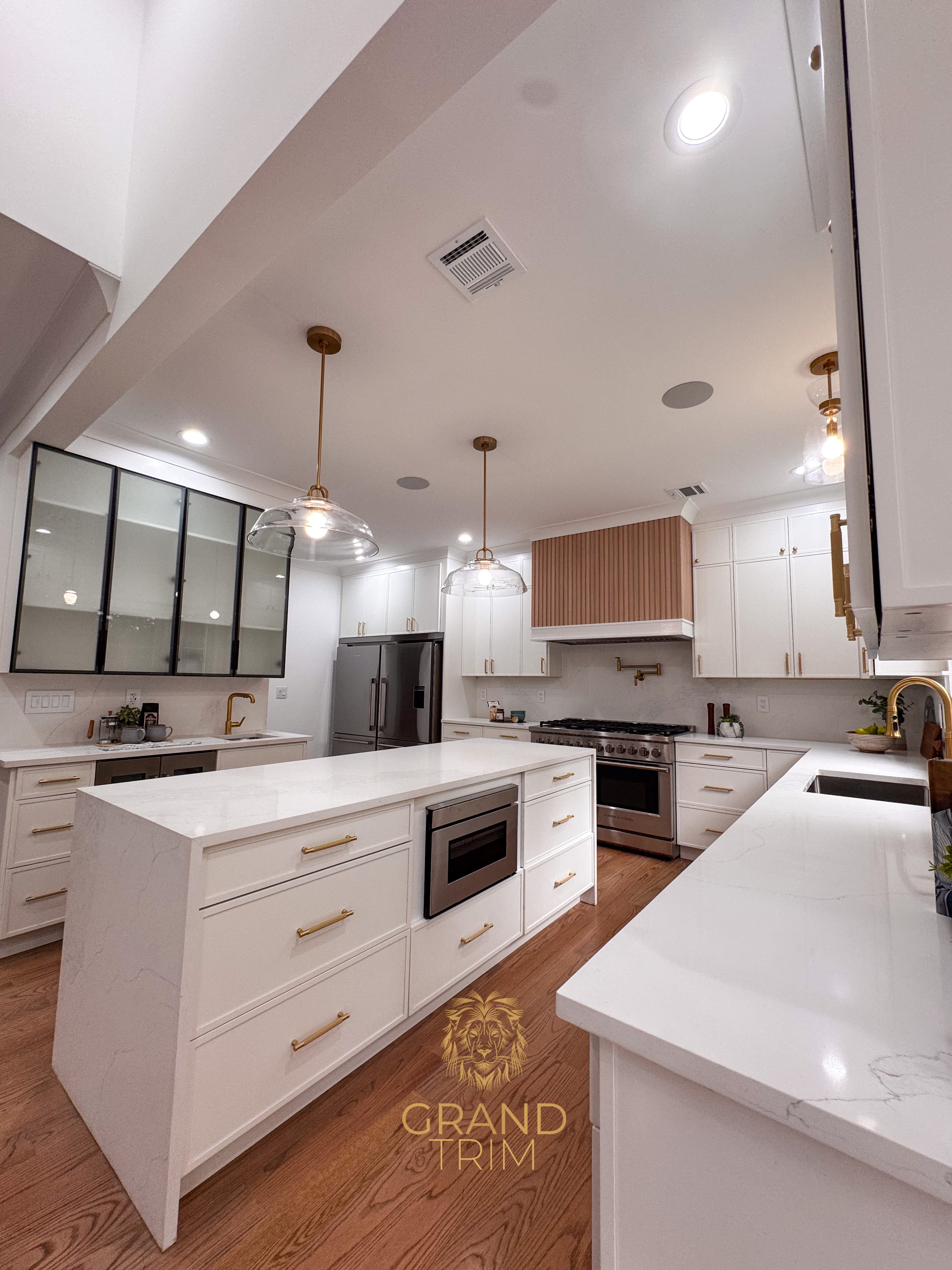 Custom white kitchen cabinetry, large island with quartz countertops, and unique wood range hood in a modern NJ kitchen