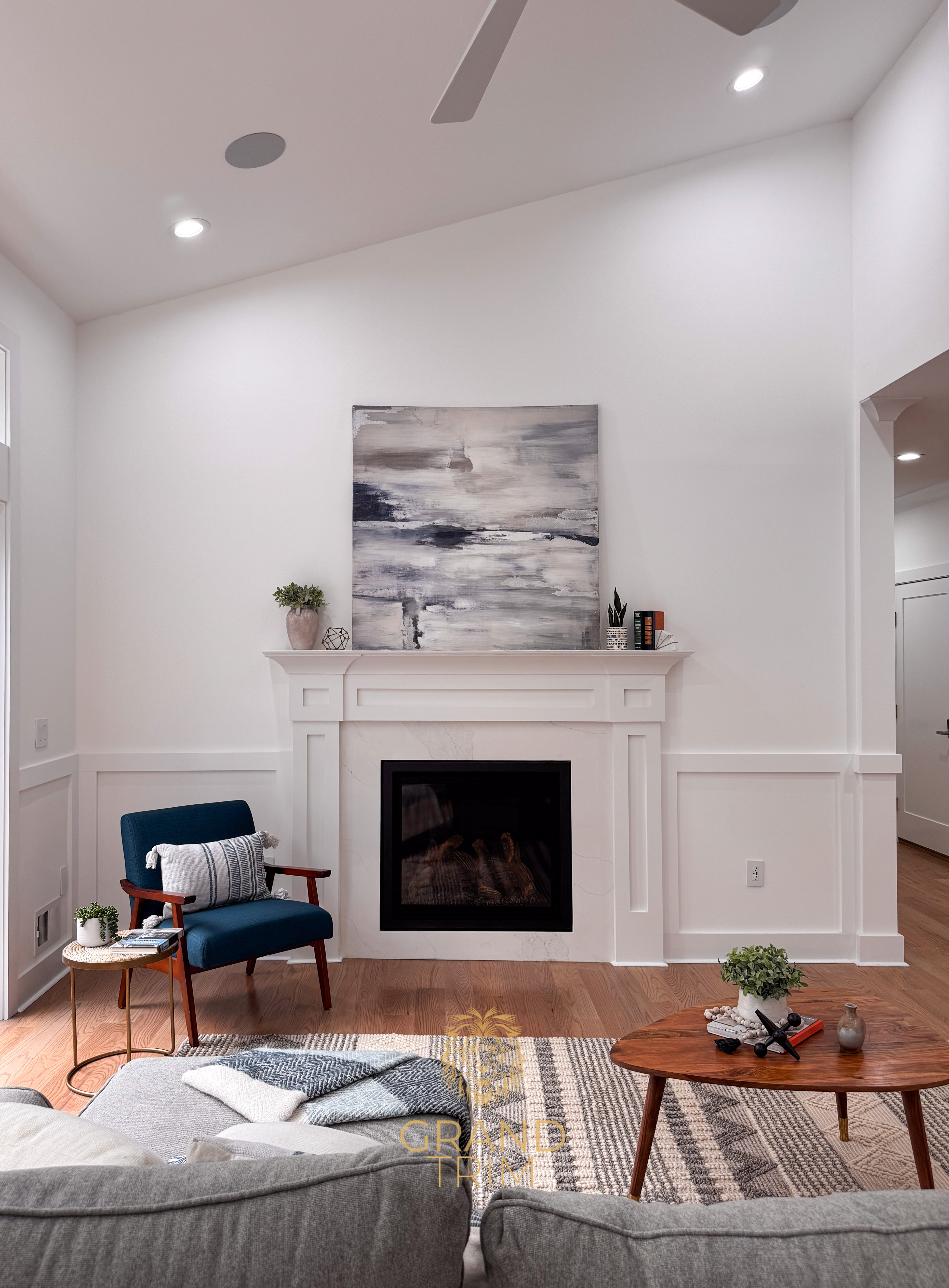 White marble fireplace mantel and surround with lower wall paneling in a NJ living room