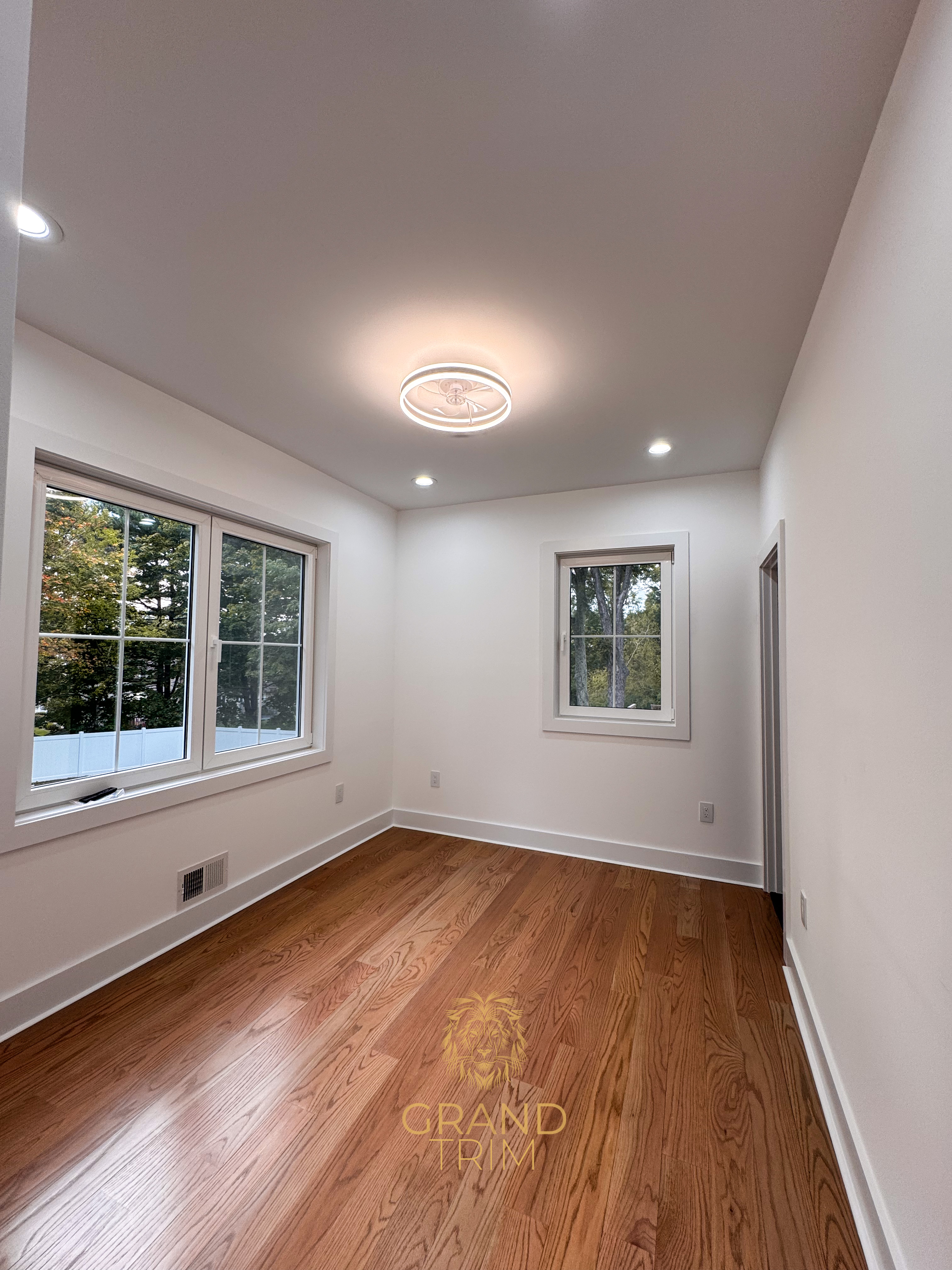 White window and door trim with matching baseboards in a newly finished empty room in New Jersey
