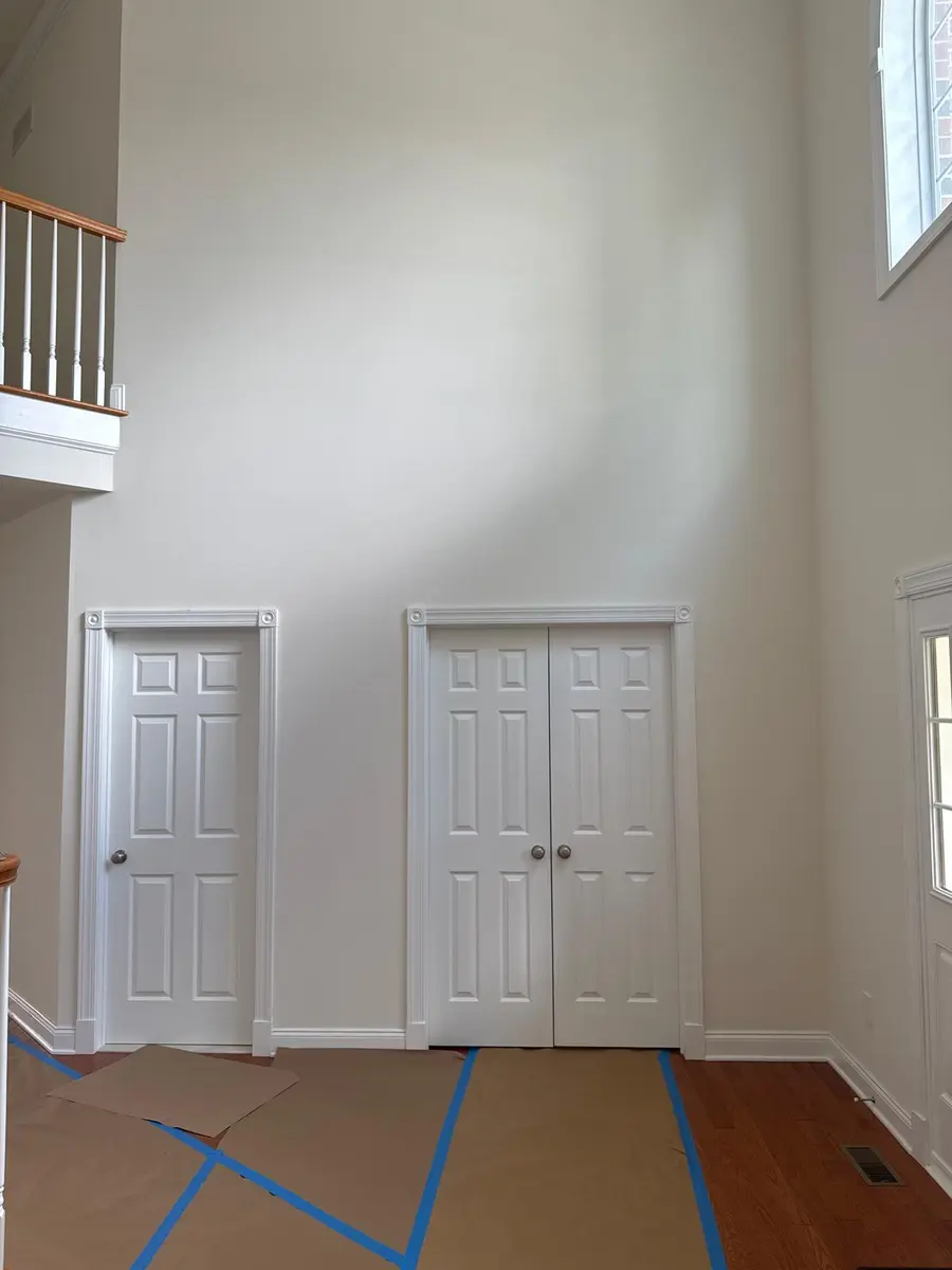 White door casing, window trim, and crown molding in a tall New Jersey home entryway