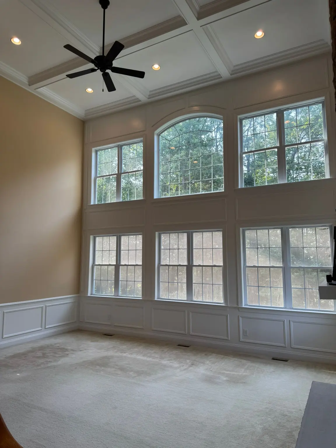 White coffered ceiling and raised panel wainscoting in a bright, spacious living room in NJ