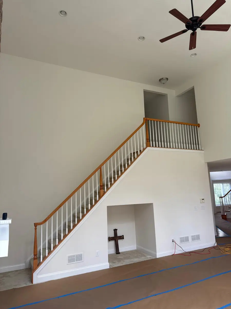 White baseboard moulding in a large room with a prominent staircase in a New Jersey home