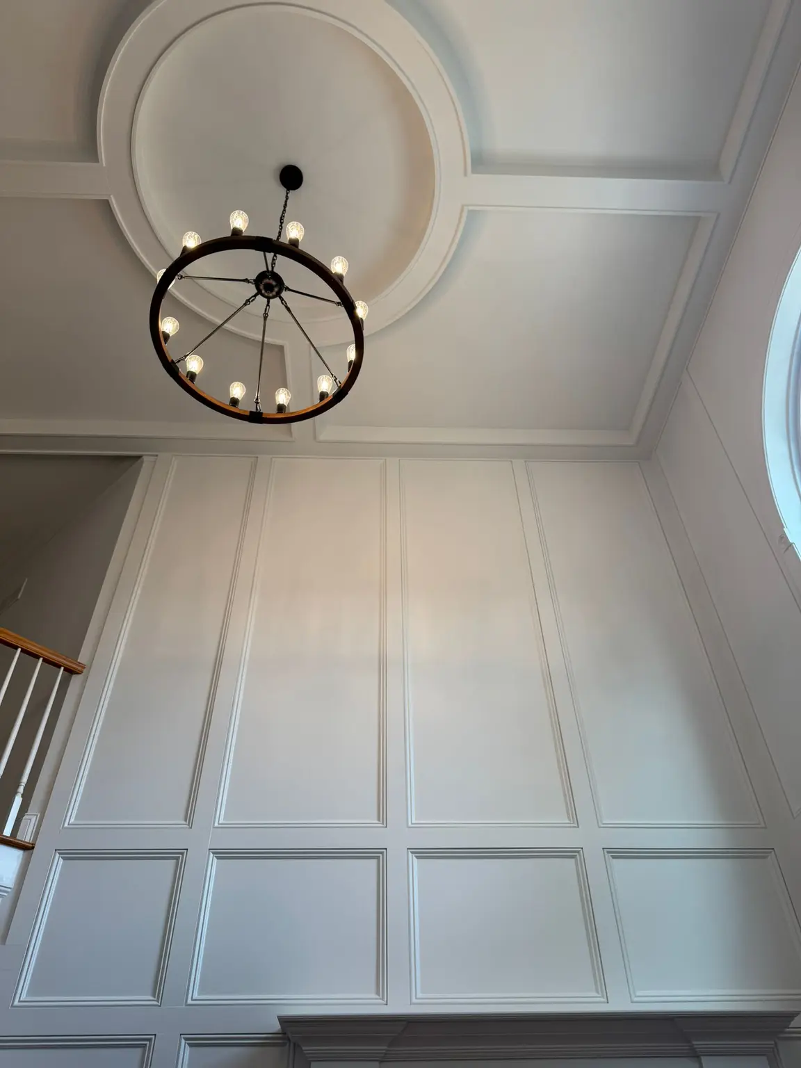 White wall paneling and a coffered ceiling with a round medallion and chandelier in a New Jersey home
