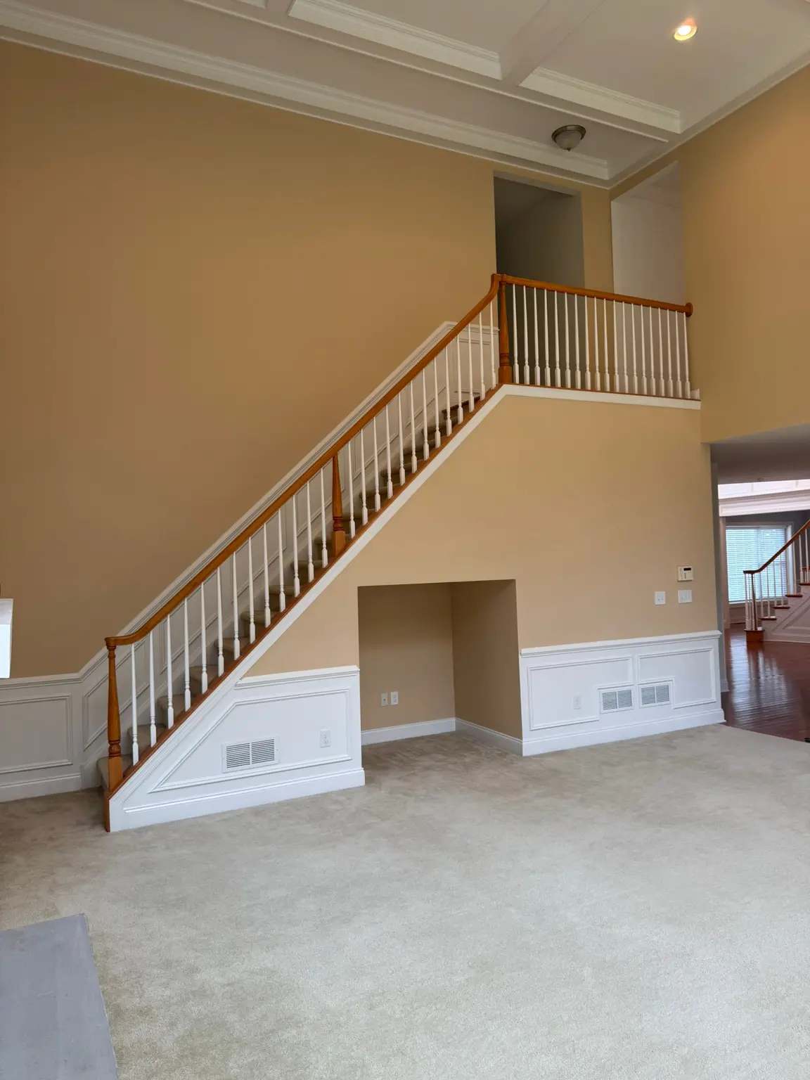 White coffered ceiling and decorative wainscoting in a high-ceiling entryway in New Jersey