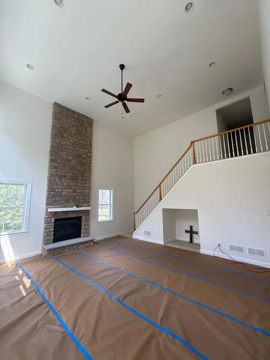 Stone fireplace with white mantel and hearth in a spacious New Jersey living room