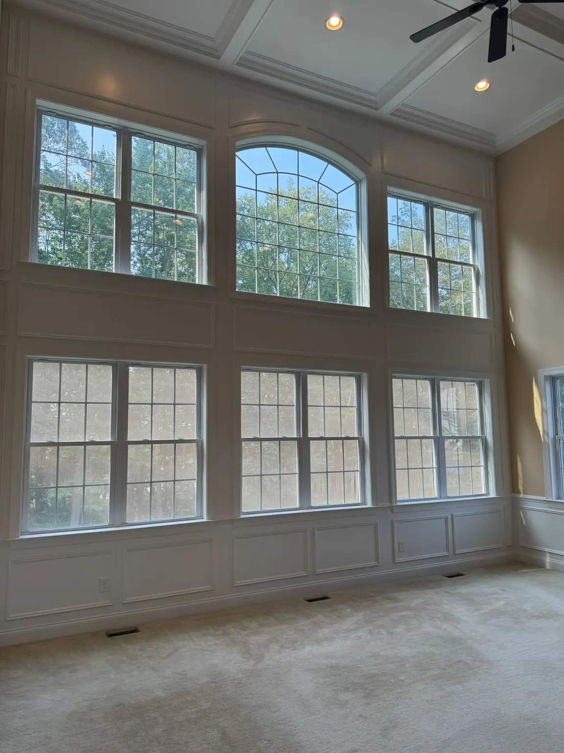White coffered ceiling and extensive raised panel wall wainscoting in a bright, spacious New Jersey room