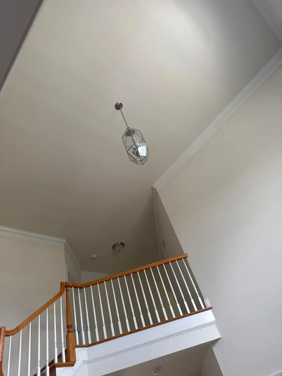 White crown molding at high wall-ceiling junctions in a New Jersey stairwell