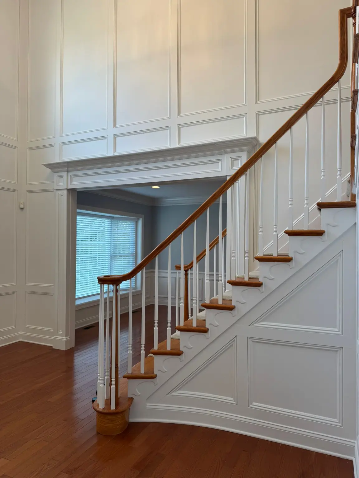 White decorative wall paneling and staircase paneling in a New Jersey home entryway