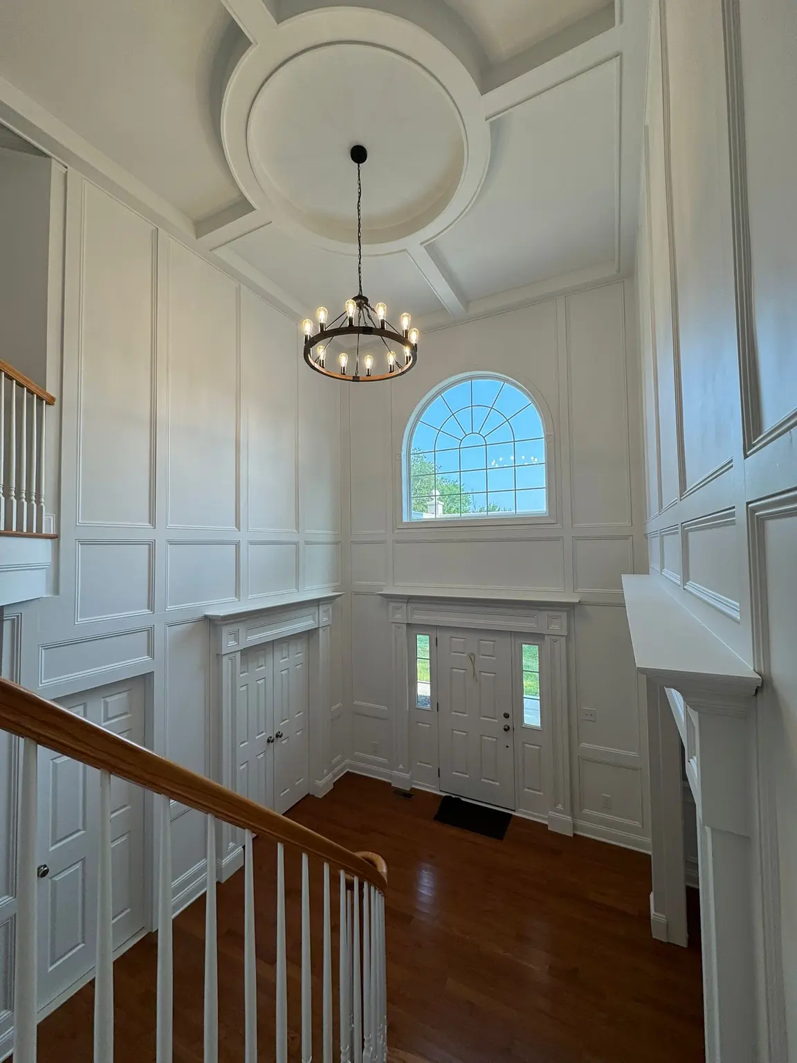 White wall paneling and coffered ceiling with a circular medallion in a grand New Jersey entryway