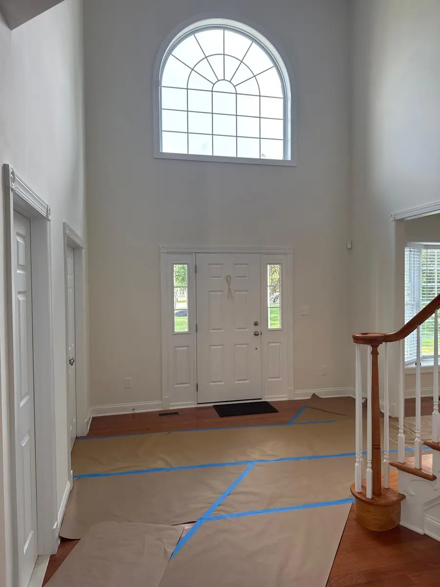 White decorative trim around entryway doors and arched window in a New Jersey home