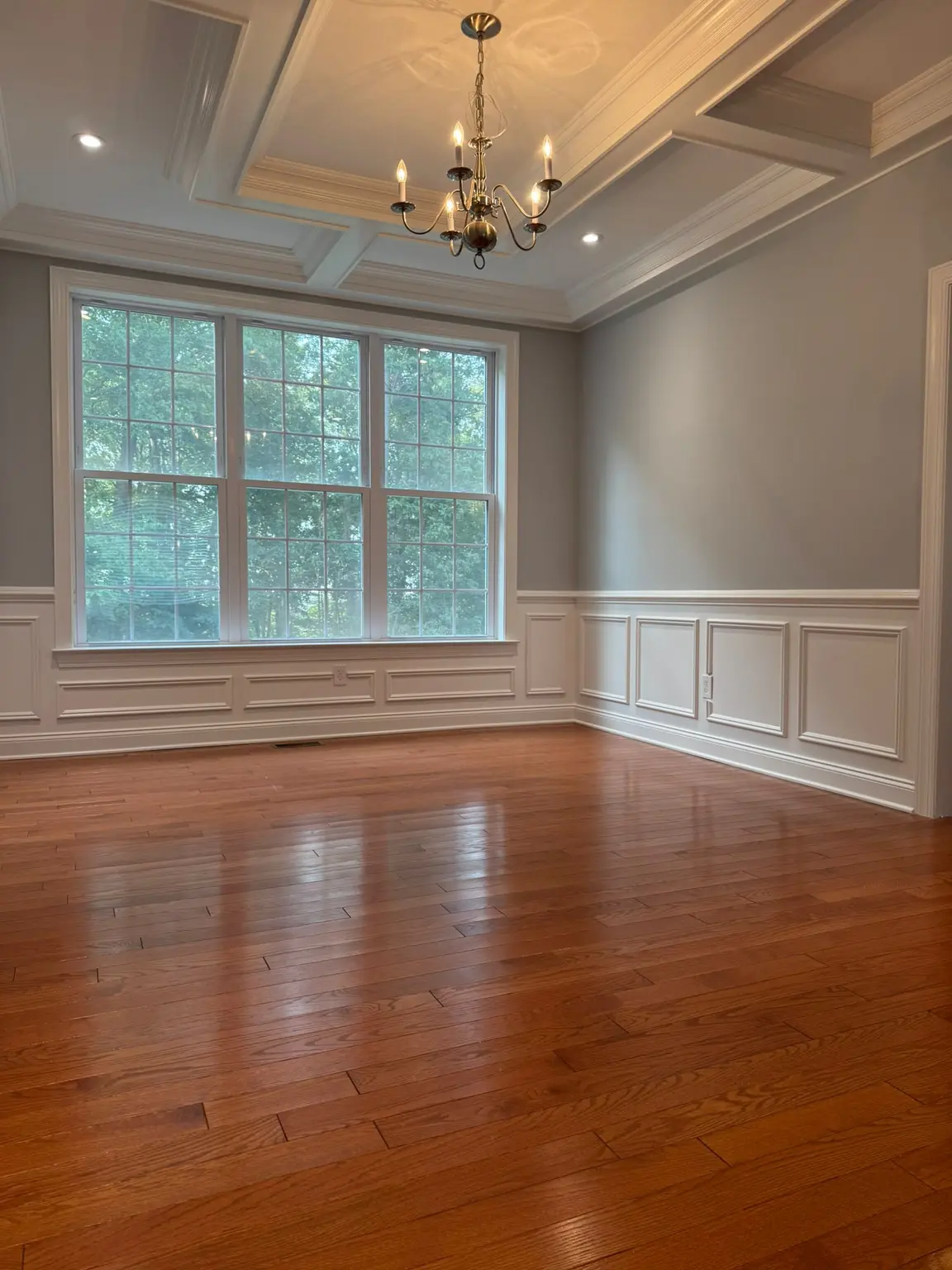 White coffered ceiling with recessed panels, wall wainscoting, and window trim in a New Jersey room