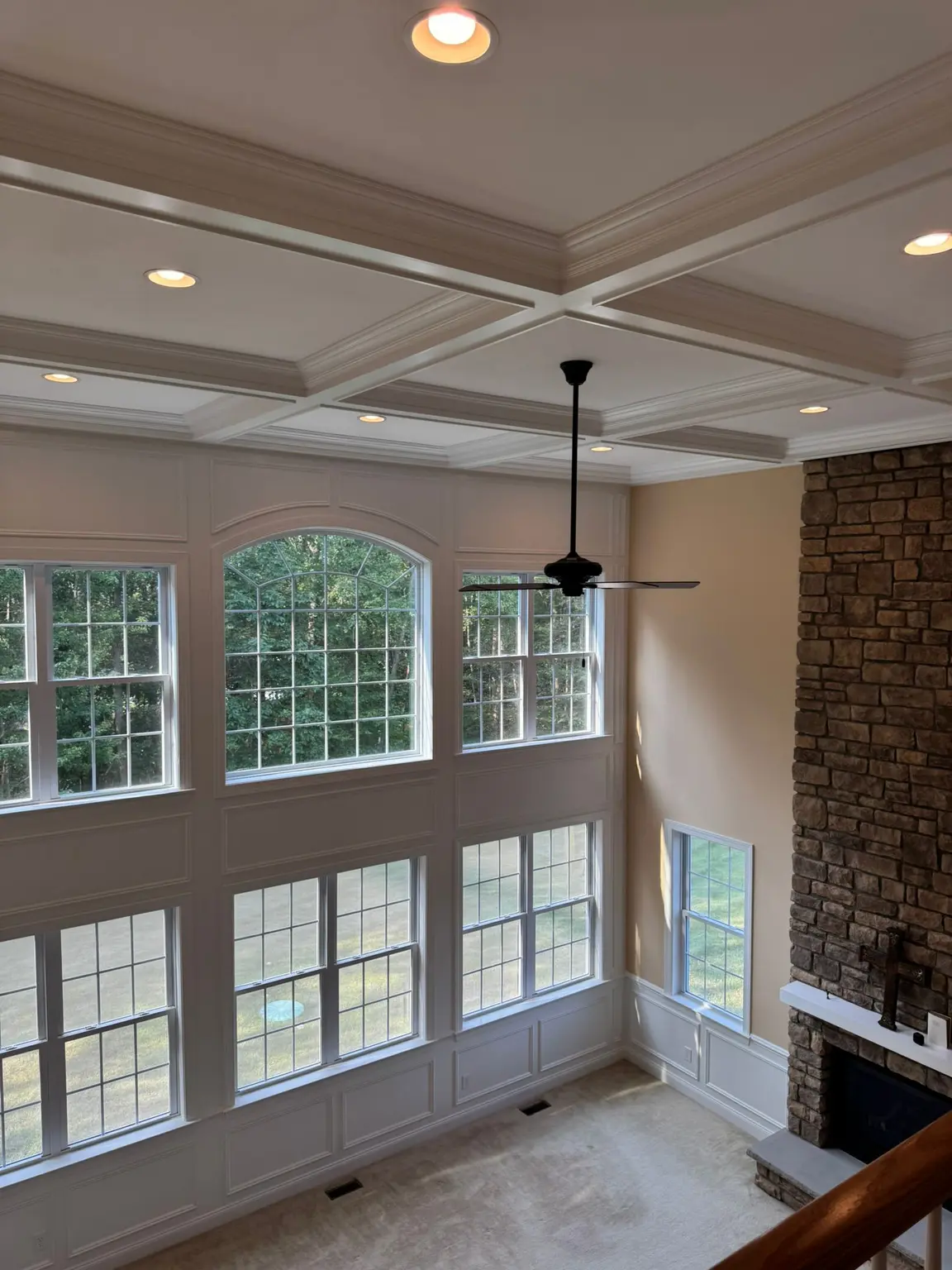 White coffered ceiling with recessed panels, extensive wall paneling, and stone fireplace in a New Jersey living room