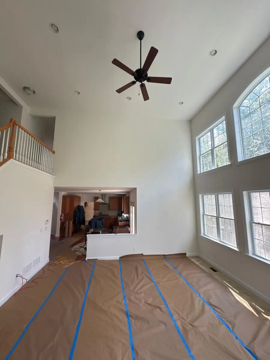 White crown molding and window trim in a spacious, high-ceiling living room in New Jersey