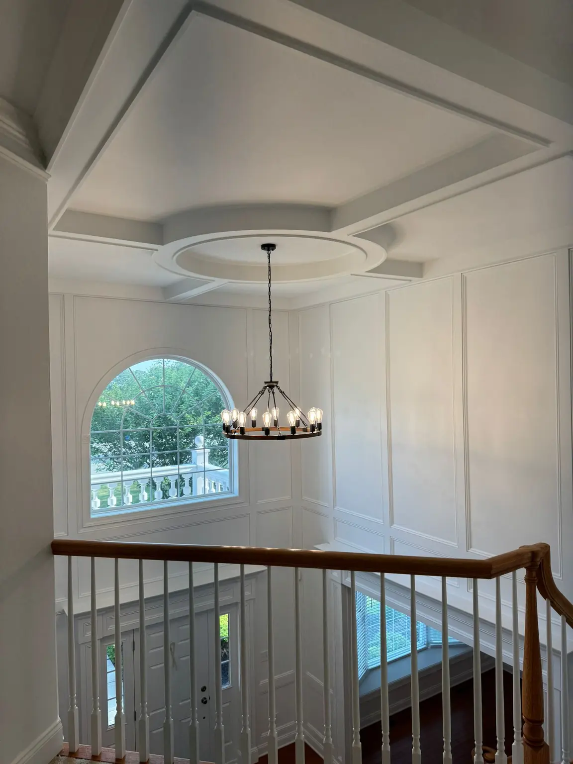White coffered ceiling with a circular medallion and full-height wall paneling in a New Jersey foyer