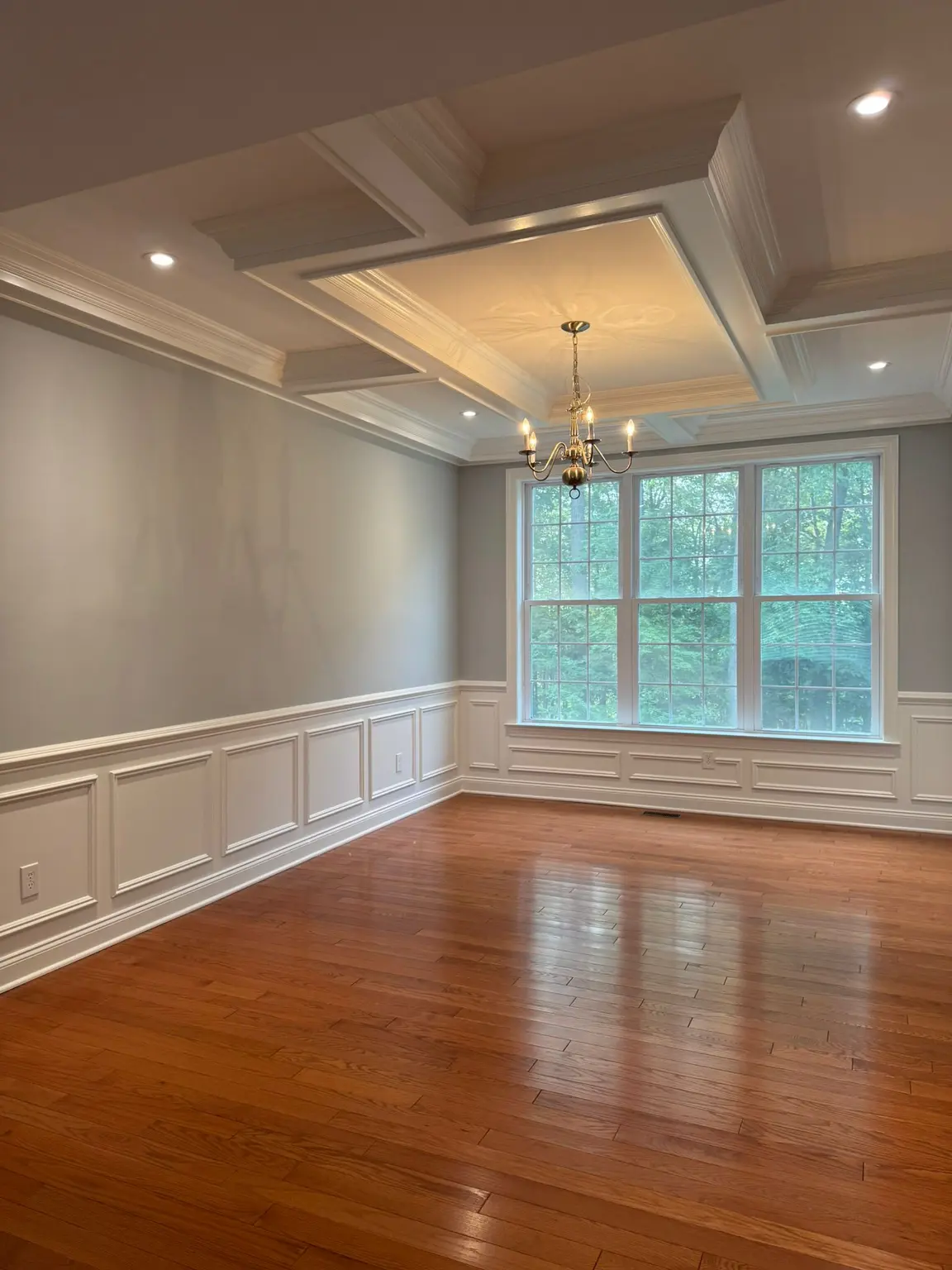White tray ceiling, detailed wall wainscoting, and elegant crown molding in a New Jersey dining room