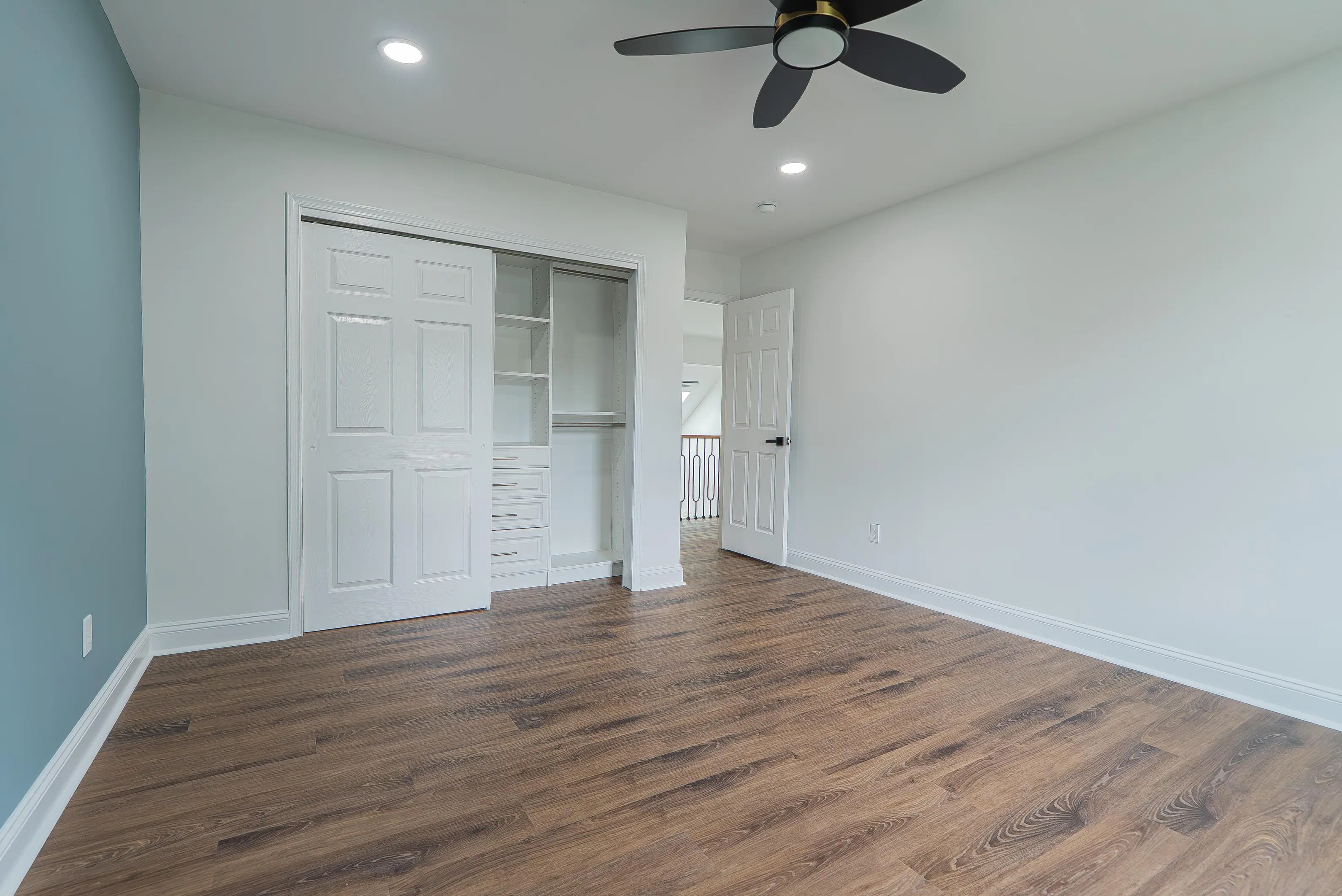 White custom closet interior with built-in shelves, drawers, and hanging rod in a New Jersey bedroom