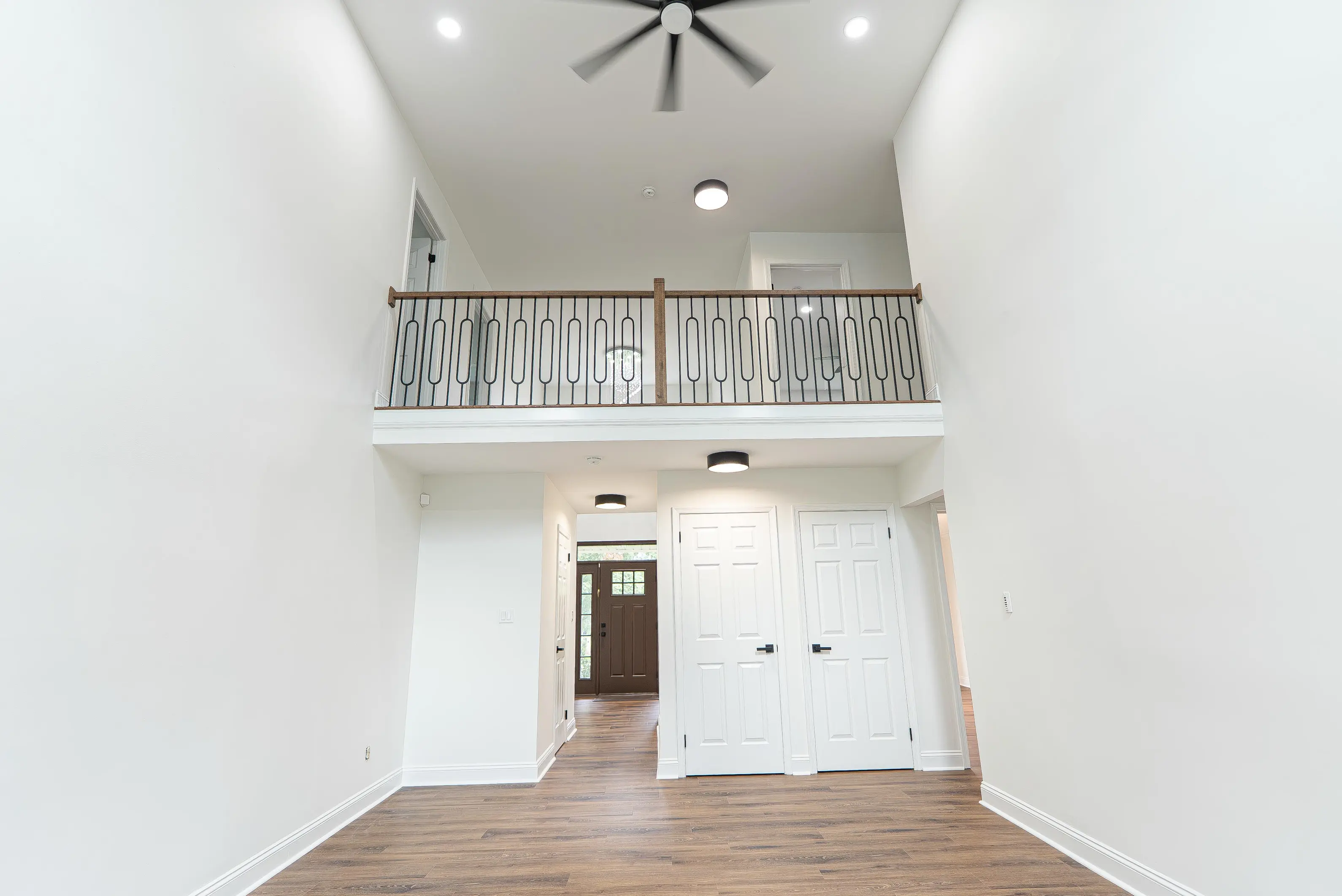 Crisp white baseboard moulding installation in a bright, empty living room with high ceilings in NJ