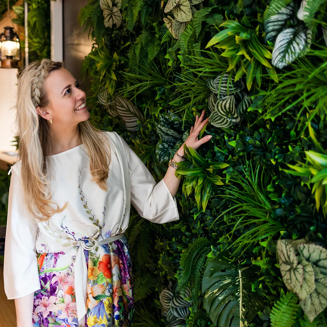 Oprichter Michelle Peterman van MiVerde bij een maatwerk groene plantenwand in de showroom