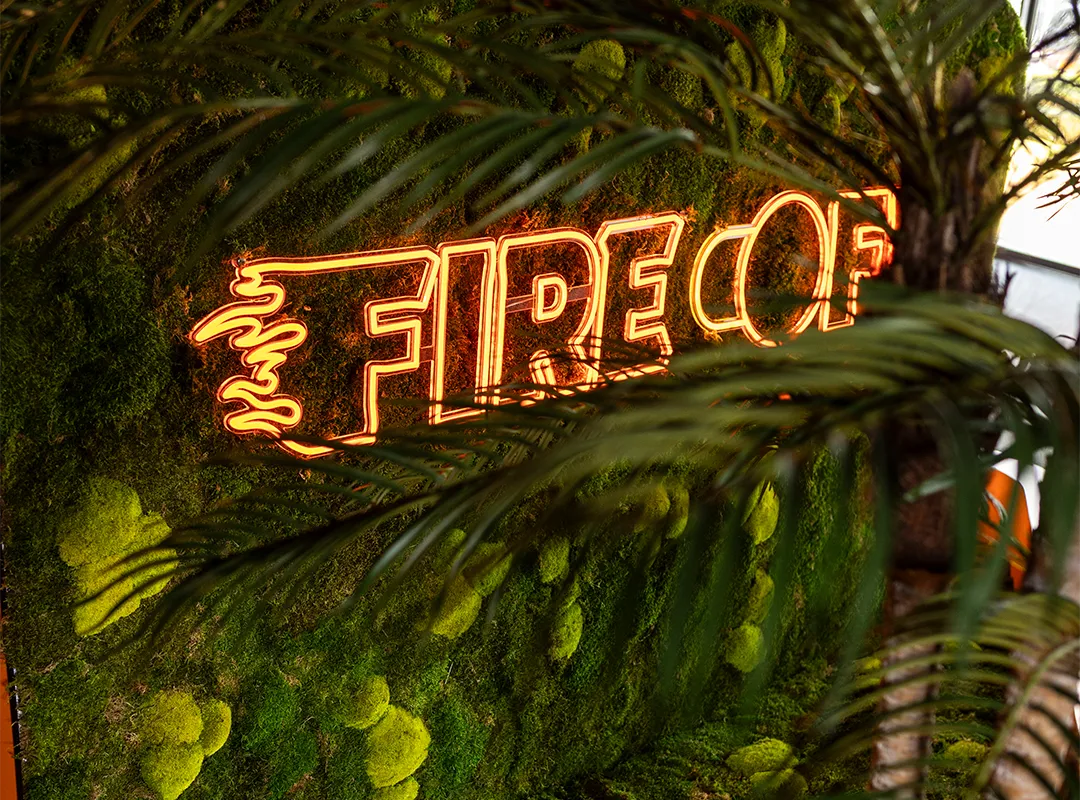 Maatwerk moswand met neonlogo van Fire of in een modern kantoorinterieur, gerealiseerd door Miverde