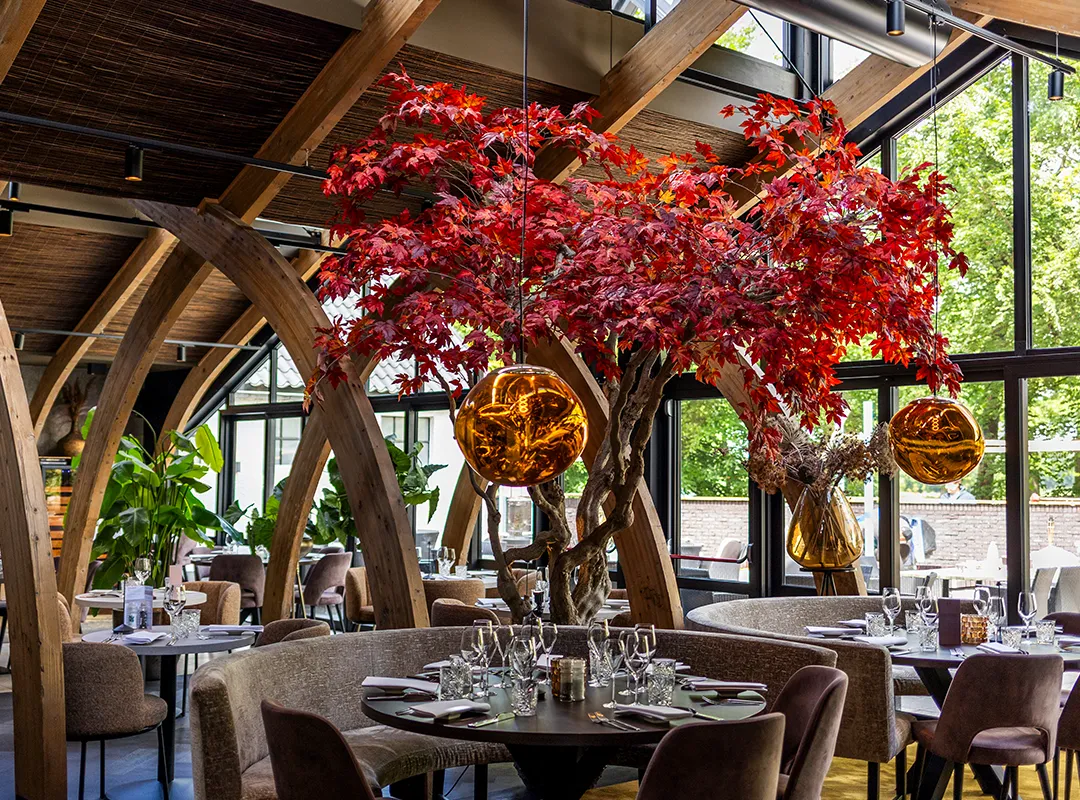 Opvallende rode maatwerk boom als blikvanger in een stijlvol restaurant met houten boogconstructie