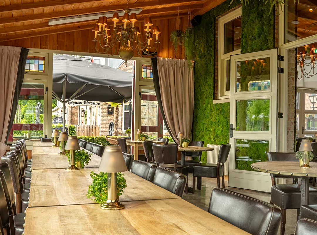 Maatwerk moswand langs de zijwand van een grote open horecazaal bij Othmar, gerealiseerd door MiVerde