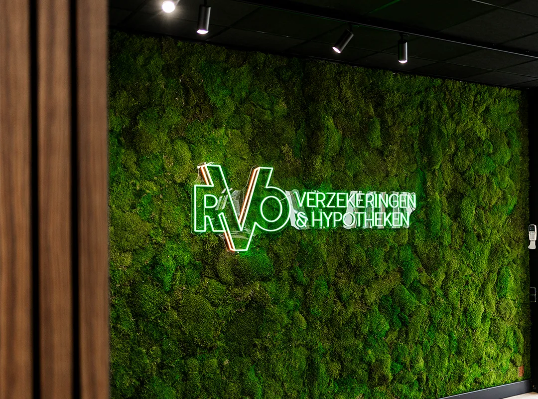 Maatwerk moswand met verlicht logo van RVb Verzekeringen en Hypotheken in een zakelijke ontvangstruimte