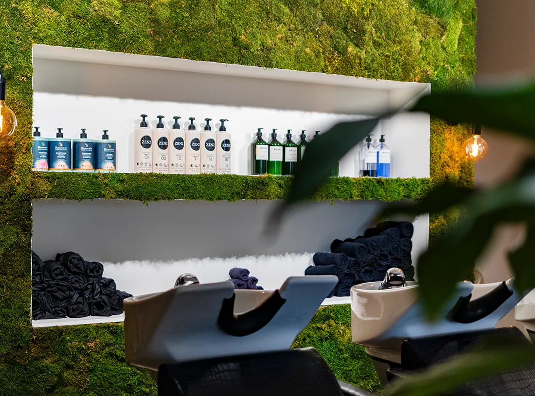 Groene moswand met ingebouwde productschappen als stijlvol interieuraccent in een moderne haarsalon