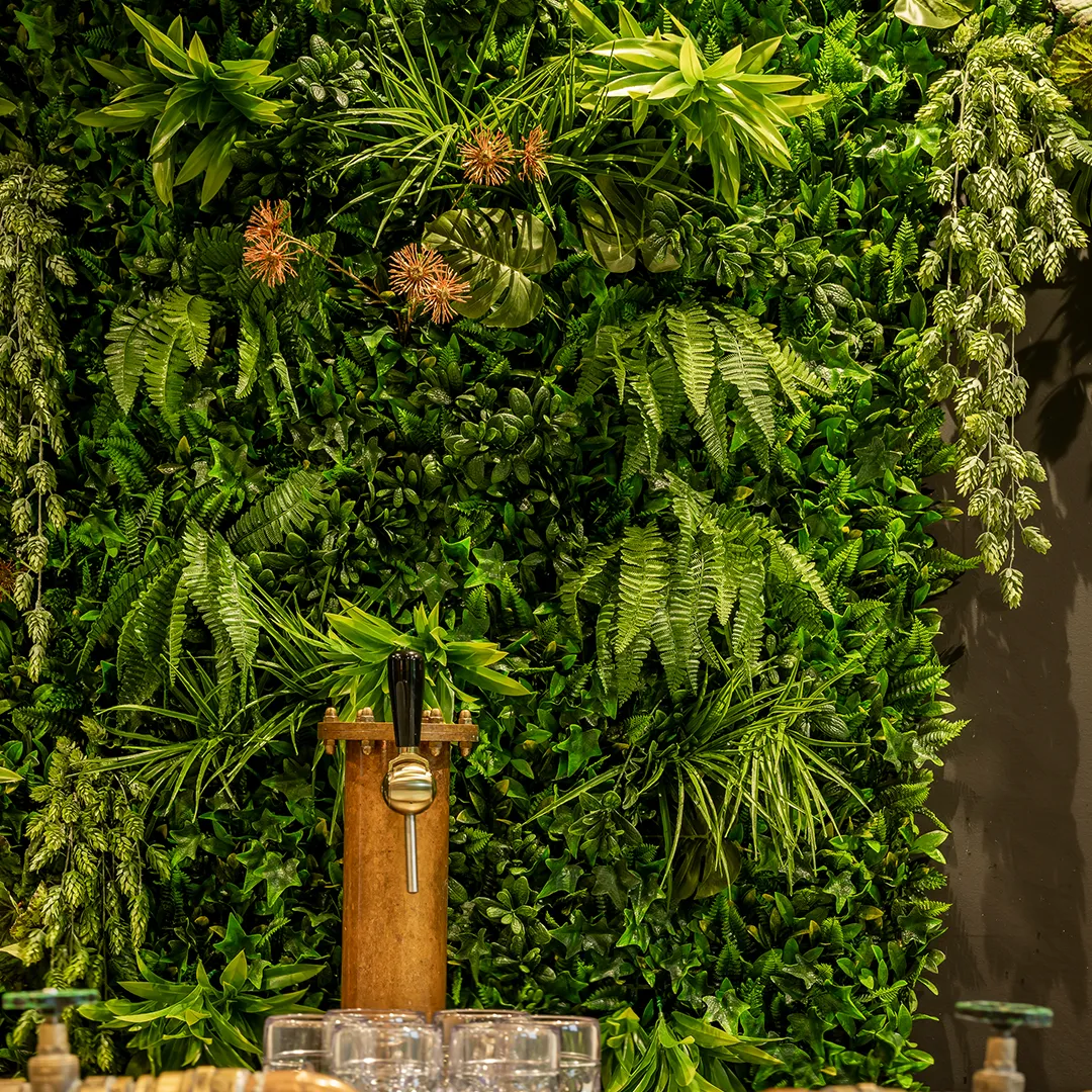 Verticale plantenwand met varens en groene planten als natuurlijke wandbekleding voor kantoor of restaurant
