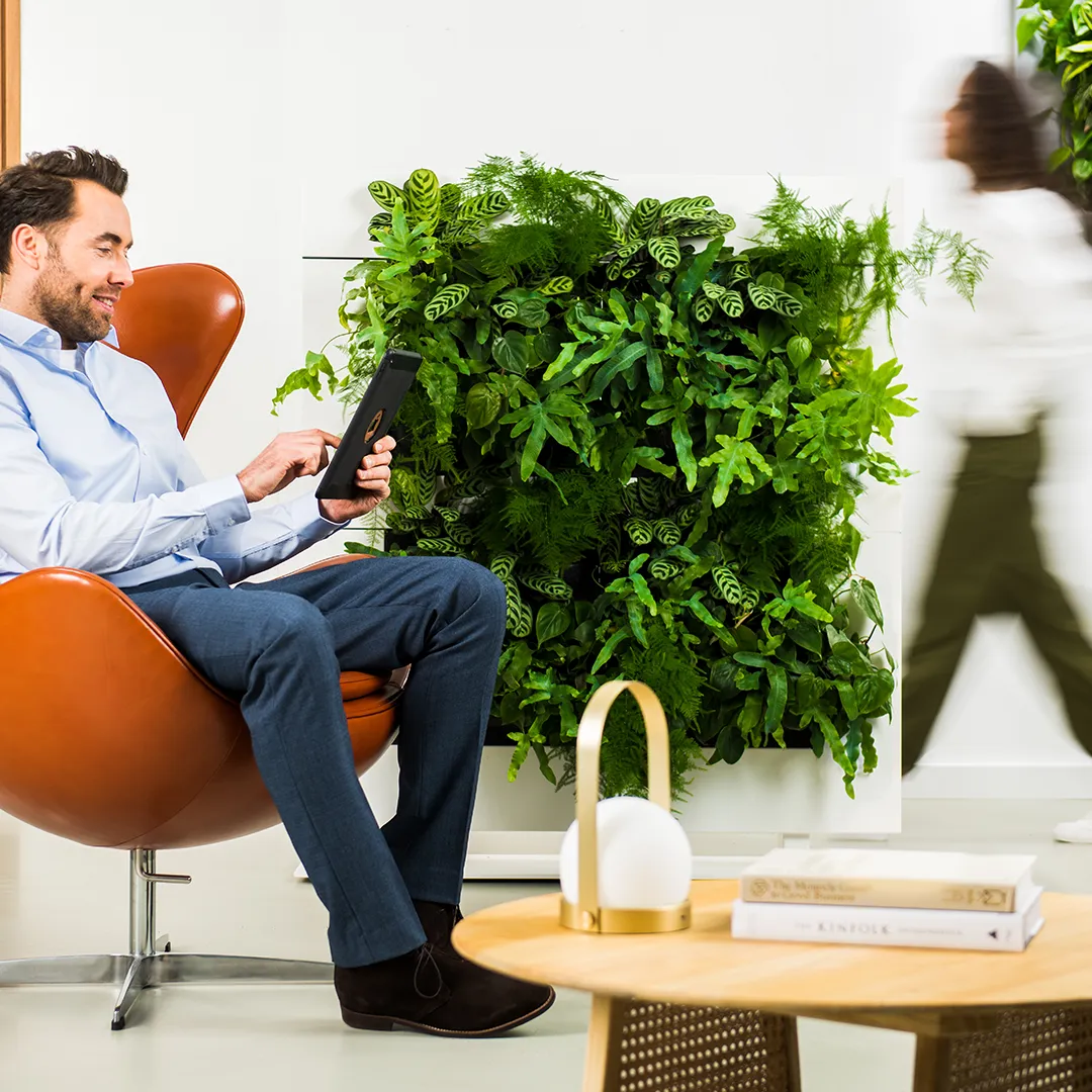 Professionele werkruimte met verticale groene plantenwand en designer kantoorstoel voor gezond binnenklimaat