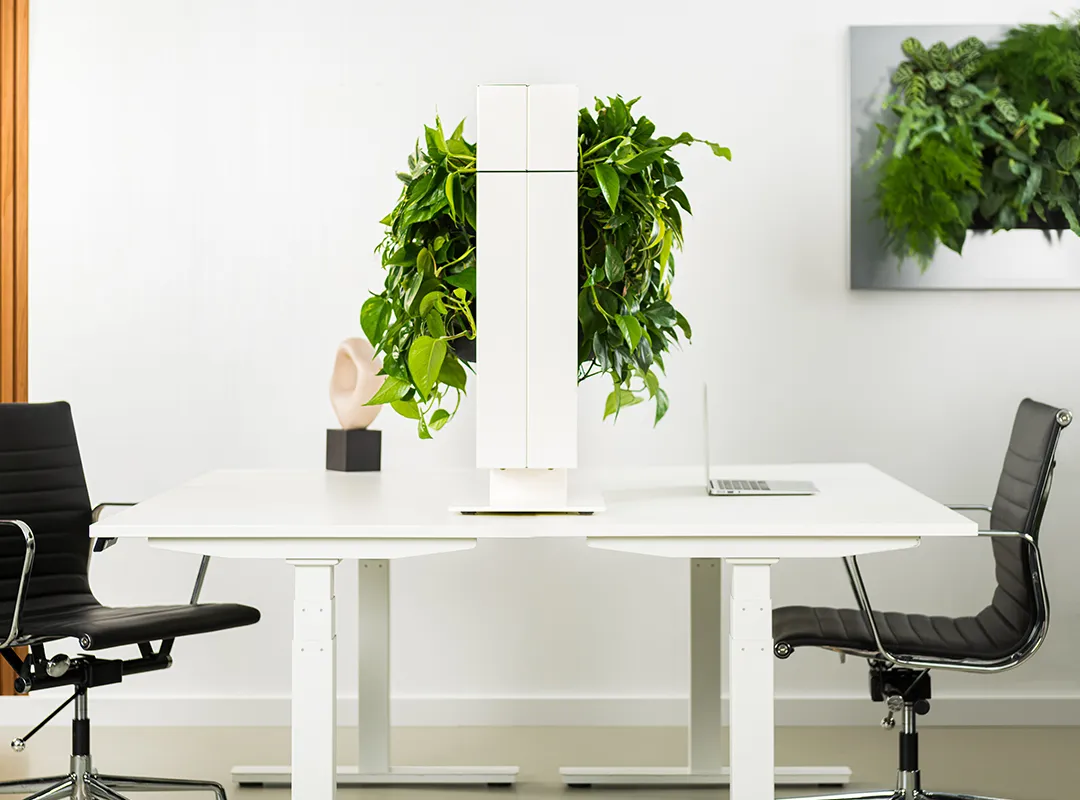 Minimalistische vergadertafel met verticale binnentuin en design stoelen in modern kantoorinterieur