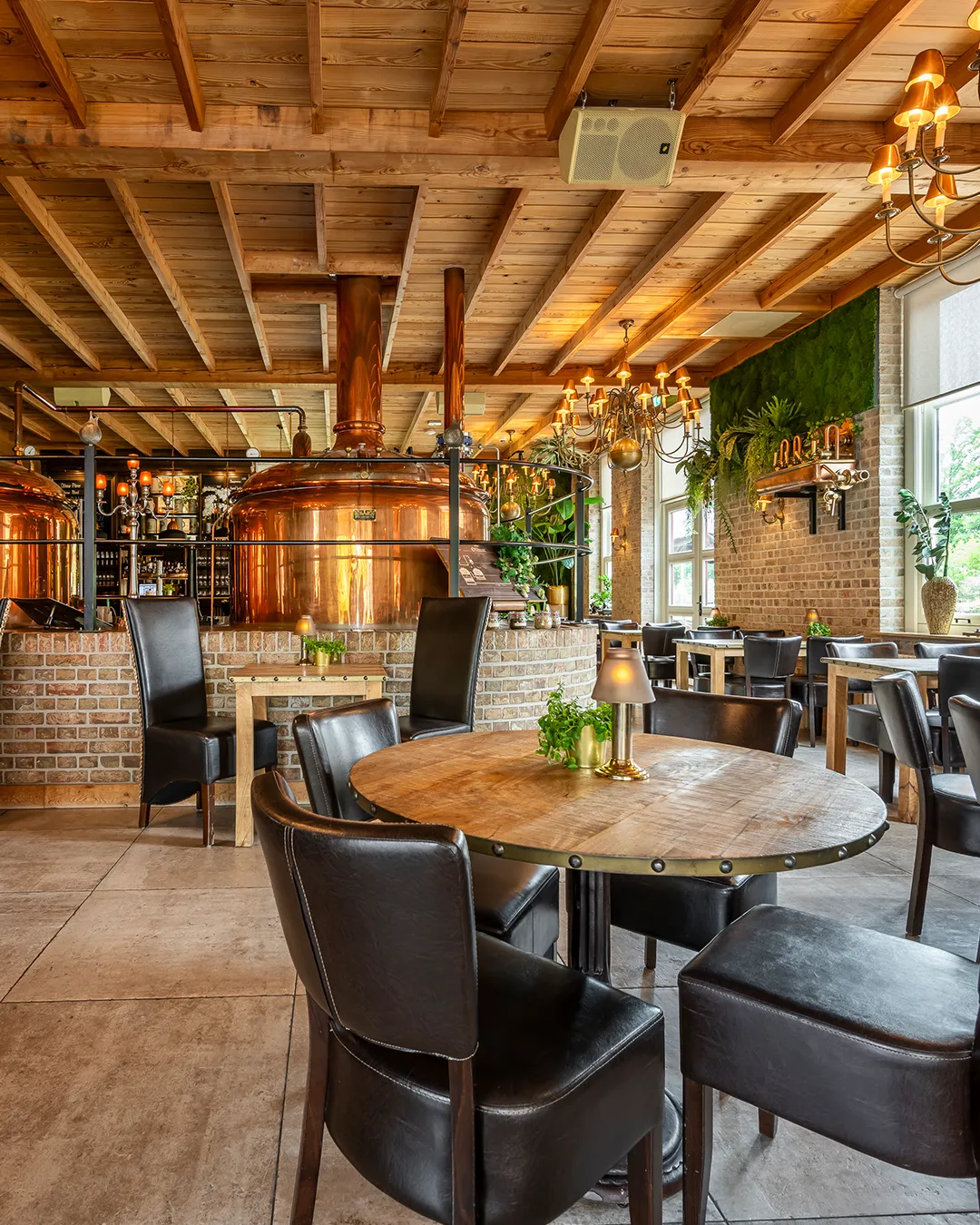 Gezellig brouwerij restaurant met koperen brouwketels, houten balkenplafond en industriële inrichting