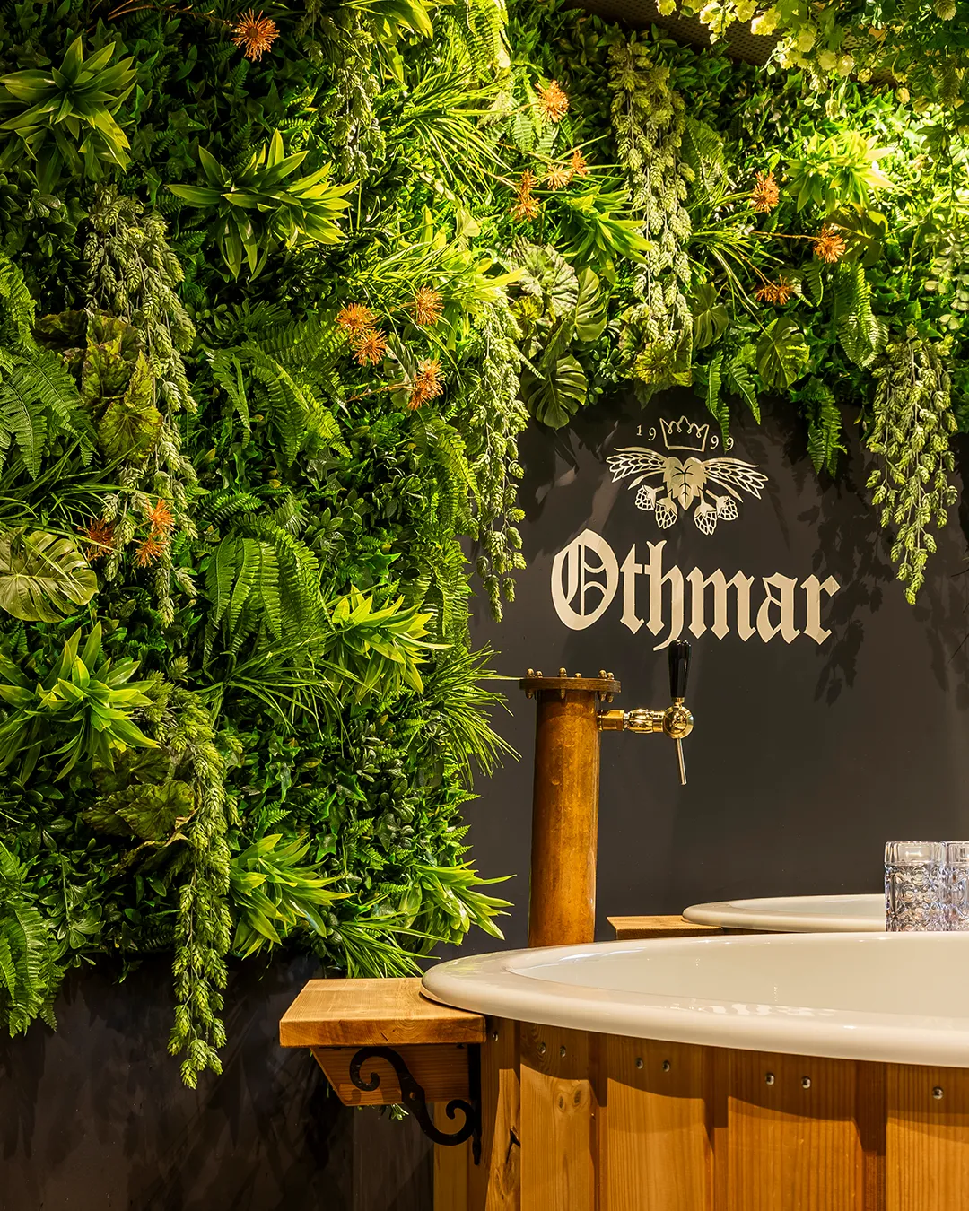 Othmar biertap met weelderige verticale groene plantenwand en houten bar in modern restaurant interieur