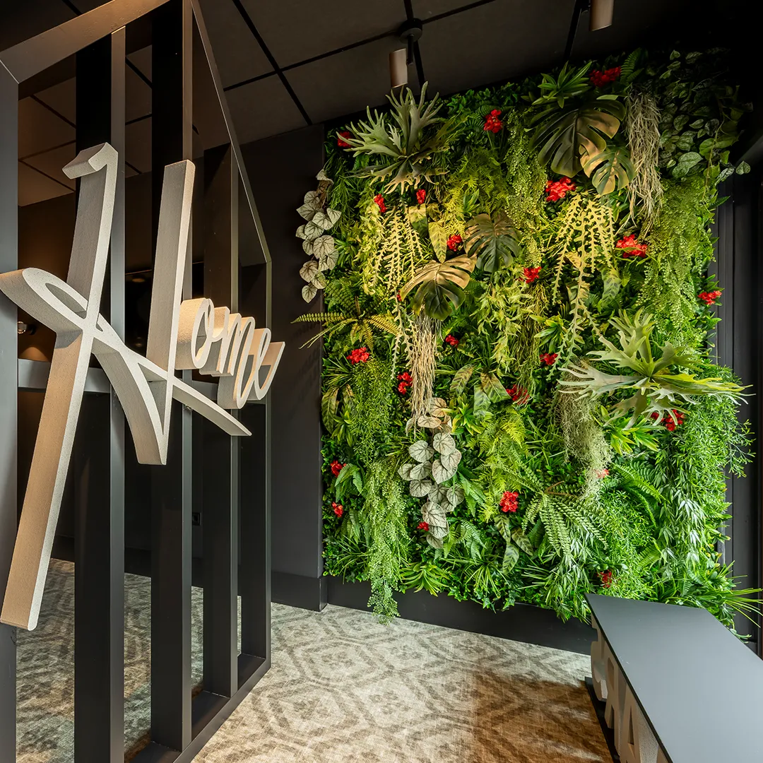 Luxe verticale plantenwand met tropische planten en rode bloemen in moderne kantoorontvangst