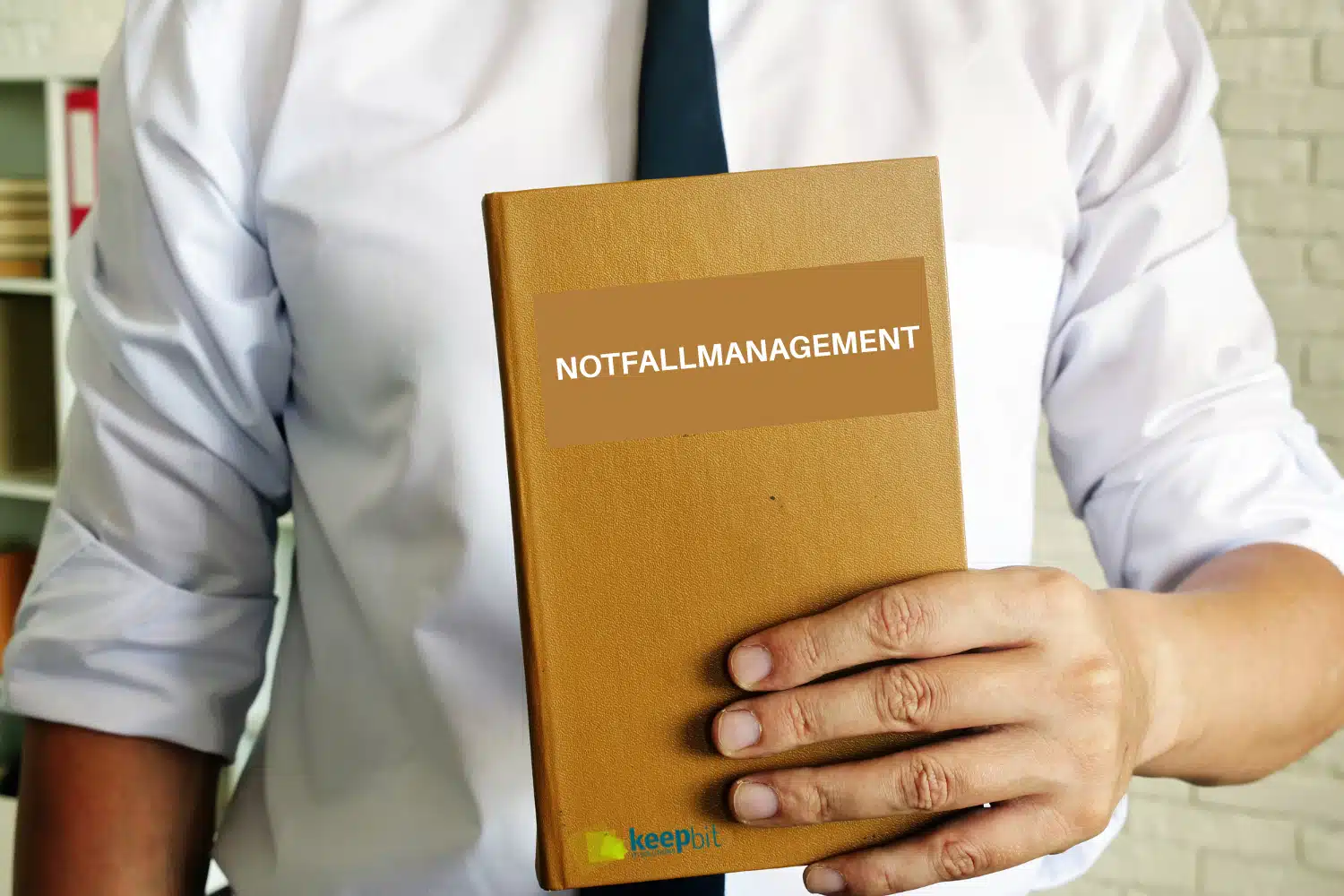 Notfallmanagement -Mann hält Notfallbuch in der Hand