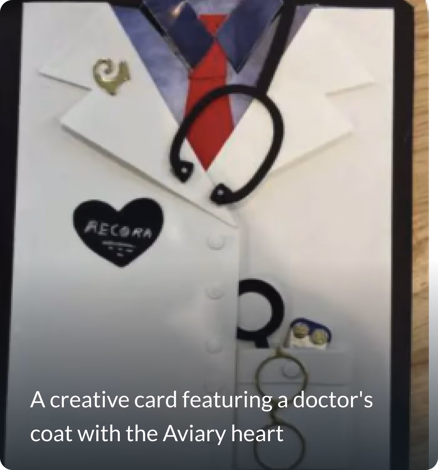 Creative card designed as a doctor's white coat with a red tie, stethoscope, and a black heart emblem reading 'Aecora'.