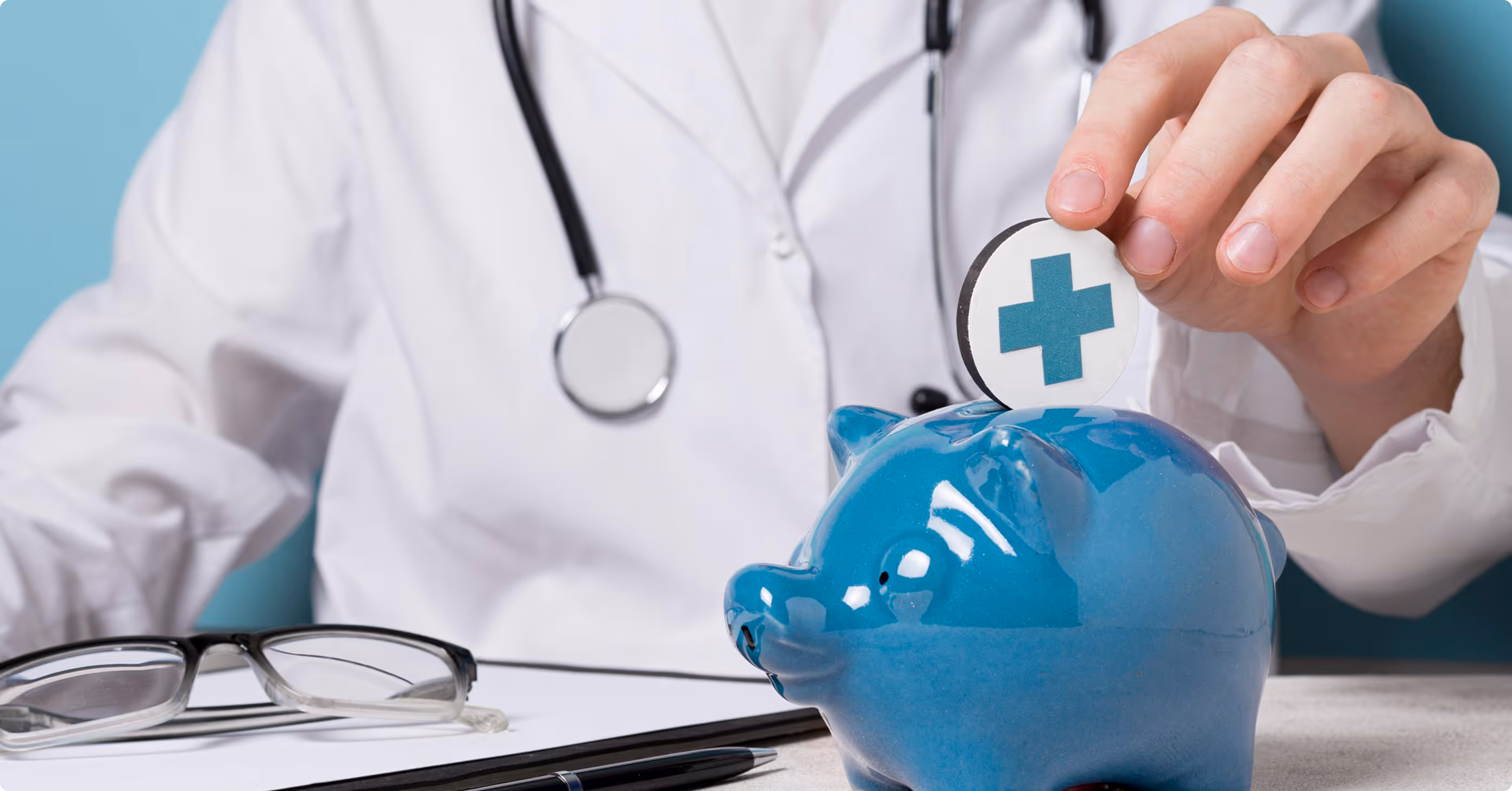 A doctor in a white coat with a stethoscope inserts a medical symbol token into a blue piggy bank.