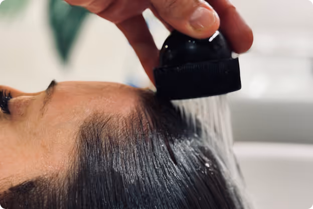 A L'Oréal Professionnel hair repair treatment being rinsed at the shampoo bowl by Team Darling at The Do Cut and Color in Dallas.