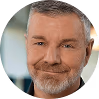 Ich weiß nicht, wer das ist.  
Lächelnder älterer Mann mit grauem Bart in Nahaufnahme, unscharfer Hintergrund.