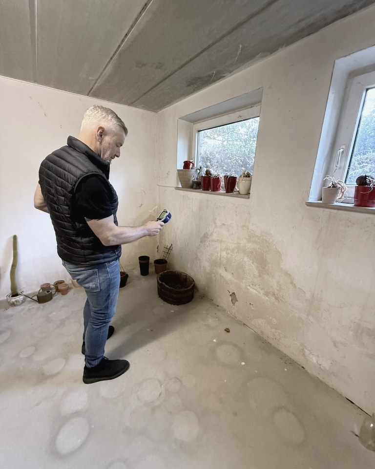 René Schulte misst die Feuchtigkeit an einer Kellerwand