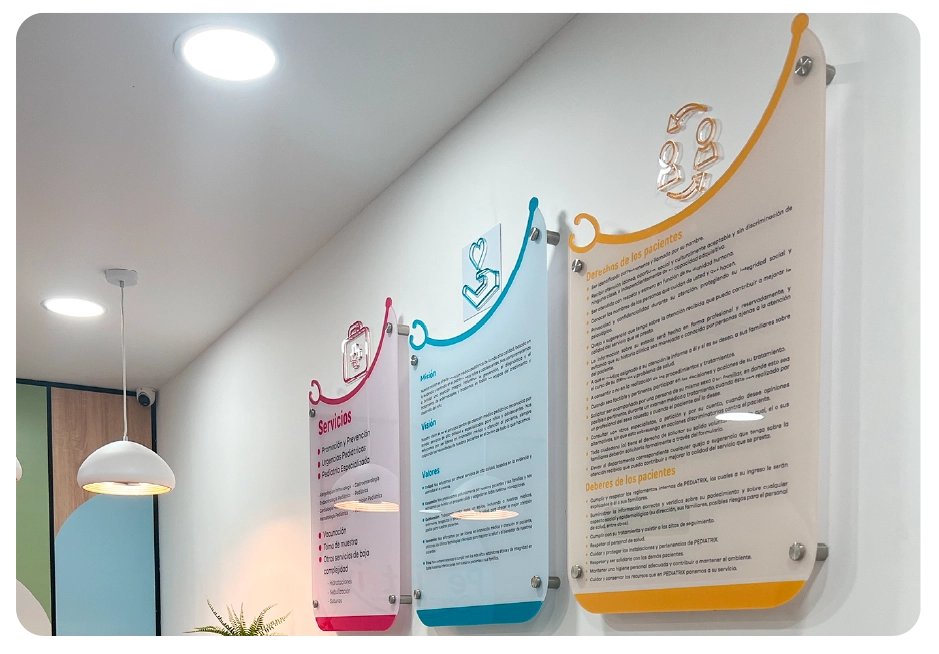 Three colorful informational wall signs in a medical office with headings: Servicios, Misión Visión Valores, and Derechos y Deberes de los pacientes.