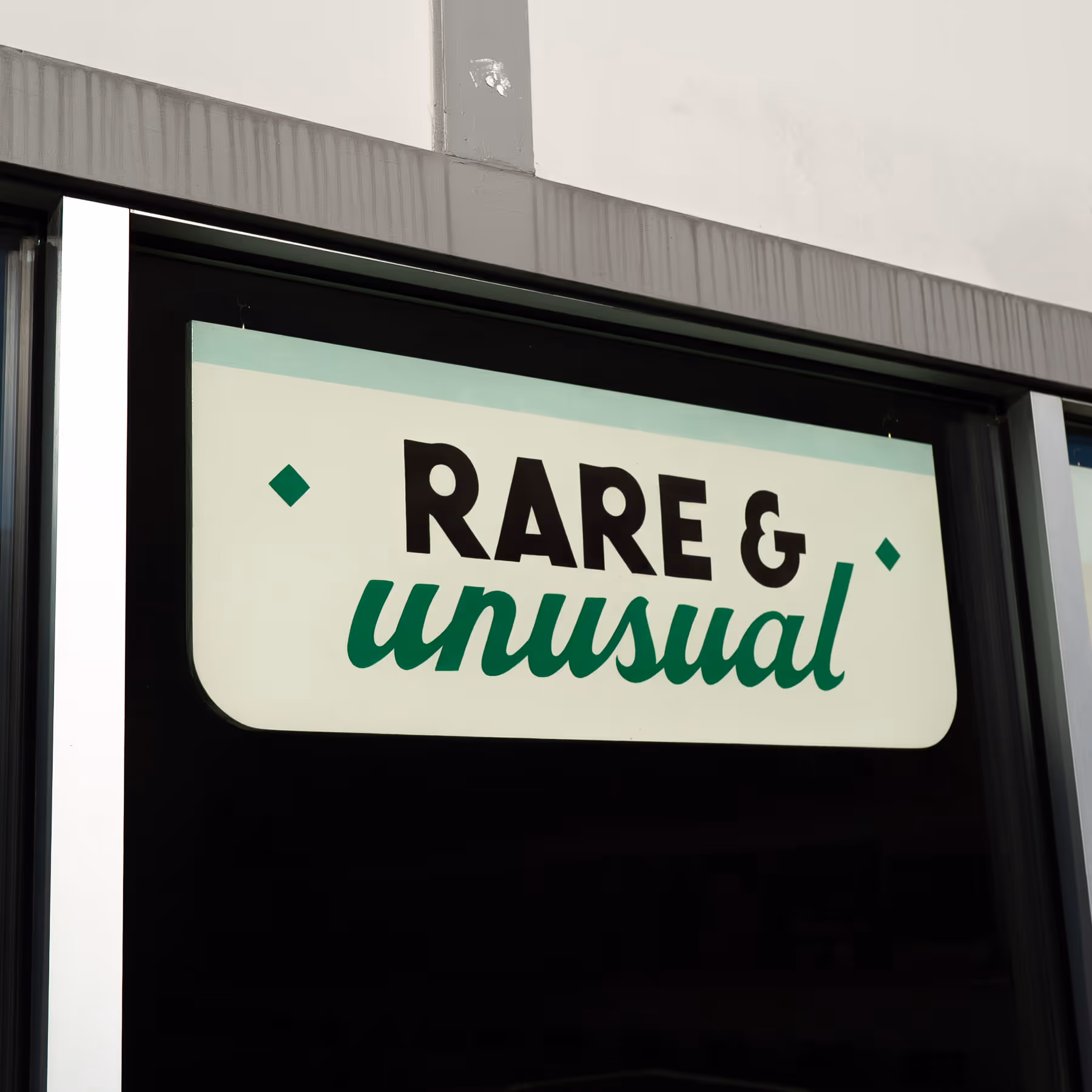 Store sign reading 'RARE & unusual' in bold black and green letters.